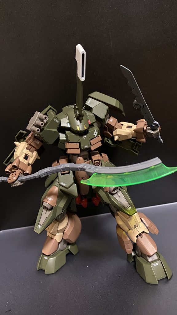 近接兵装として、左肩シールド内側にビームアクス、腰部にフォールディングブレードを装備。右肩に三連グレネード。