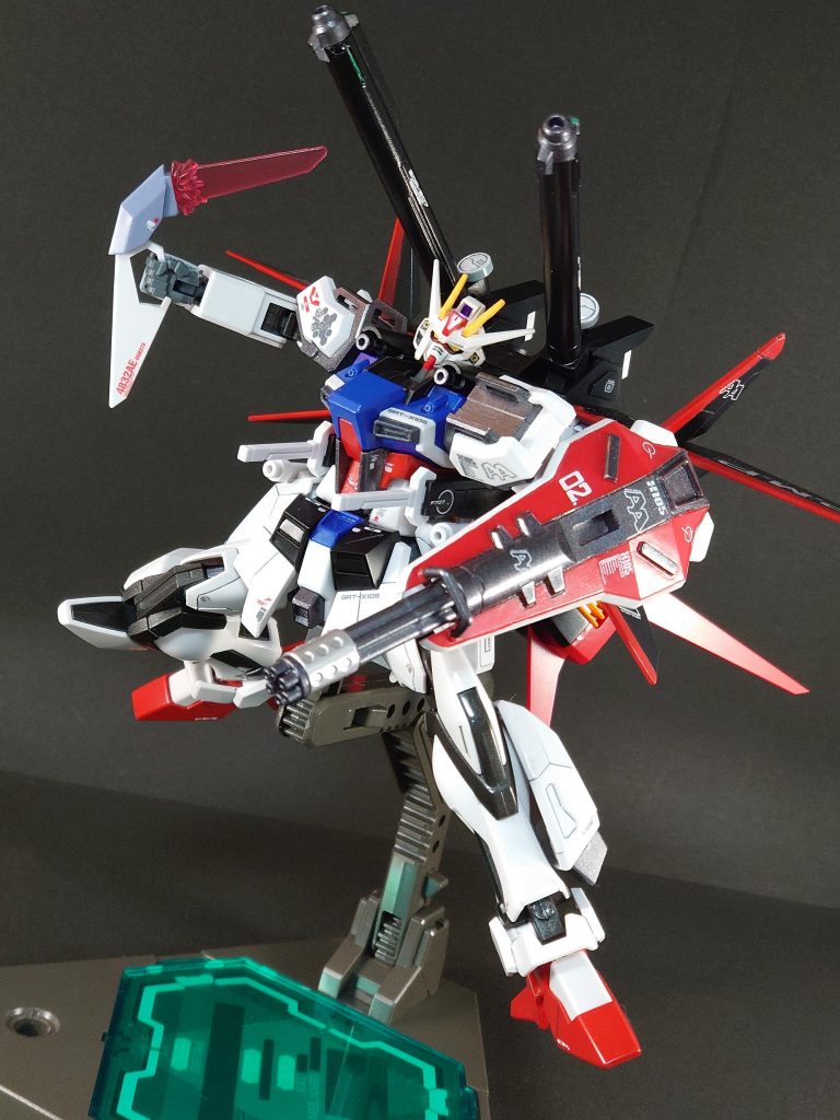 製作にあたって、ストライクが好きな気持ち、ビルドダイバーズで使用する機体、本編(SeedやDestiny)でも通用することをテーマにしました。ストライクの、本体に黄色が無い事でおもちゃっぽくなく、しかし適度にアニメのロボットという絶妙なイメージを崩さない様に配色しました。また、こういった最新鋭機では無いロートル機を活躍させるには機動力を上げ、被弾を抑えるのが良いという持論に基づき各部にスラスターを追加しました。ストライクといえばパワー切れですが、フロントアーマーの左右についている2つの黒いブロックを外付け電池としています。(バスターの膝の赤いやつもバッテリーらしいです。それを参考に考えつきました。グゥレイト!)これによりI.W.S.P.を運用できるようになっています。以下画像