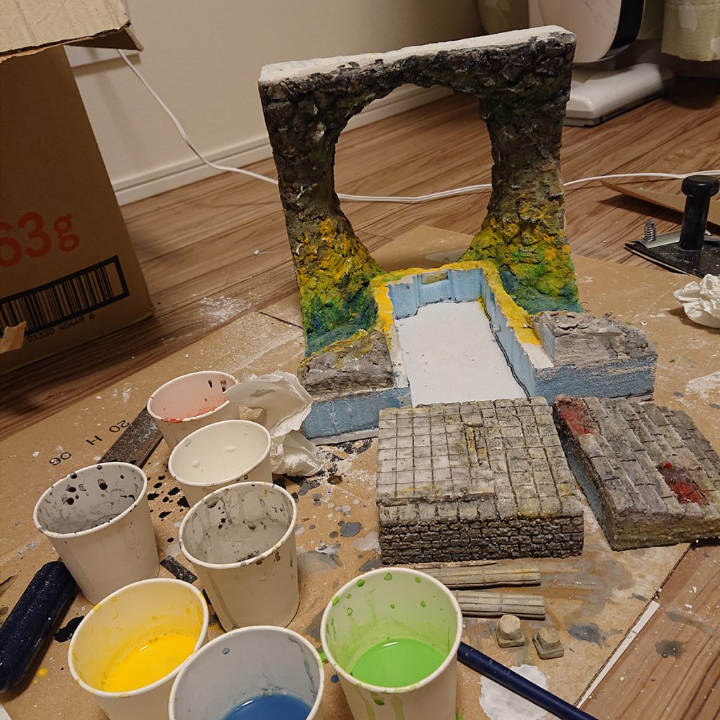 着色はアクリル絵の具を水で薄めてジャブジャブ塗りつけて混色しました。岩肌は海面付近で反射して明るい色に、上にいくほど暗くなるようグラデを付けました。海面はグリーン着色剤を混ぜたレジンを流して、大波小波で波を付けました。