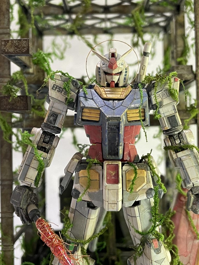 【妄想設定6】地球圏のニュータイプたちによって土星圏の暗い影はすでに察知されていた。しかし、200年以上大きな争いがなかったために軍事産業は衰退しており、戦闘用のMSは一年戦争時ほどの性能にまで低下していた。軍艦もなく、防衛船という小規模テロ組織用の小型戦艦があるだけで「ソーレ・ノッテ党」率いる戦闘用MSおよび軍艦に対抗しうる兵器がなかった。そのため、電撃侵攻してきた「ソーレ・ノッテ党」はわずか3ヶ月で地球の半分を支配。地球圏のサイド郡も次々と降伏していった。ソーレ・ノッテ侵攻から6ヶ月。遥か昔、日本と呼ばれた地域は経済特区として地球と各惑星における貿易の要となっている。トーキョー港、ヨコハマ港は地球有数の宇宙港でもあるため、ソーレ・ノッテもかねてから奪取のための動きを見せていた。ついいソーレ・ノッテのMS「リゼス」3機がヨコハマ港に威力偵察をしかける。街と港が焼かれていくなか、MS高専に通う17歳の少年マサキ・イシイはリゼスの攻撃によって抉られた地面の中に古いドックを発見する。そのドックは蔦のような苔に覆われていた。マサキはその中に白い白鳥が飛んでいくのを見てドックへと走る。ドックには見たこともない古いMSが屹立してる。最初期のMSで操作系統は操縦桿を使うクラシックなもの。エンジンが外部にあり、MS本体とはケーブルで繋がれていた。再びリゼスの攻撃で大きく揺れるドック。このままでは死ぬと感じたマサキはコックピットに乗った。ここなら死なないかもしれない。しかし、座席に座った途端にMSが起動してしまう。状況に混乱するマサキ。するとモニターの向こう側に古い連邦軍の制服を着た少年が空に浮かんでいるのを見た。少年は声を出さず「ガンダム」とマサキに告げる。「ガンダム？こいつの名前か？これで何をしろっていうんだ？」少年は何も言わずに消える。直後、ガンダムに気付いたリゼスが接近してくる。無我夢中でコンソールパネルに触ると、ドックごと地上へと上昇。追いかけてくるリゼス。何か武器はないか？コンソールパネル右下には背中に刺さっている２本の筒が点滅しているのが見えた。右側の筒をタッチ。コンソール左上に「ビームサーベル　アンロック」と表示されたがマサキは見ていない。モニター正面に迫るリゼスがビームアックスを振り上げる。「このおおおおおっ！」マサキが無我夢中で操縦桿を前に押し出す。ガンダムの両目が光り、ケーブルで繋がれている熱核エンジンを引きずりながら前に出た。それを見たリゼスが一瞬怯む。ガンダムはビームサーベルを引き抜き、スパークと共にビーム刃を発生させてリゼスを両断した。爆風がガンダムを包む。ガンダムおよびドックに絡みついていた苔のほとんどが吹き飛ぶ。実に1000年の時を超え、白いモビルスーツ「ガンダム」がヨコハマで再起動した瞬間だった。---妄想設定は以上です！長文を最後まで読んでいただき、ありがとうございます！以下、制作内容およびコンセプトなどを書いております。 