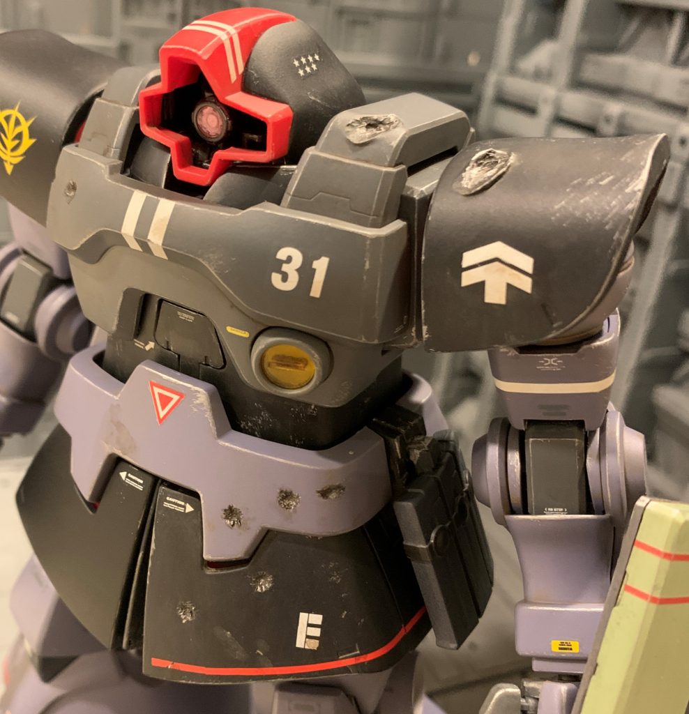 ジャブロー攻略戦という激戦をかいくぐった機体なので、バトルダメージは避けて通れないと思い恐る恐るトライしました。ジャブロー戦では連邦軍が本格的にジムを投入し始めていたので、トーチカや100mmマシンガンなどの実弾兵器で被弾した箇所に加え、今回はビームスプレーガンで被弾した想定で熱で溶けた感じのダメージにもチャレンジしました。実弾痕はピンバイス+デザインナイフで抉り、ビーム痕はガスコンロで熱したドライバーを当てて溶かしました。ダメージ加工は一発勝負なので毎度緊張します。損傷の激しい装甲は新品に交換してしまっている設定なので、交換するほどではない軽ダメージを意識して控えめにしました。