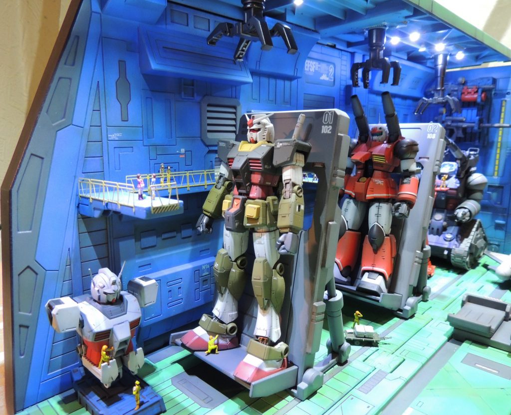 先頭のガンダムの正面には、部品取り用という設定で、別機体のボディの上半分を設置。また、アムロ、フラウ、ハロ、連邦軍士官等のフィギュアを置き、ＭＳの巨大感の演出を試みました。