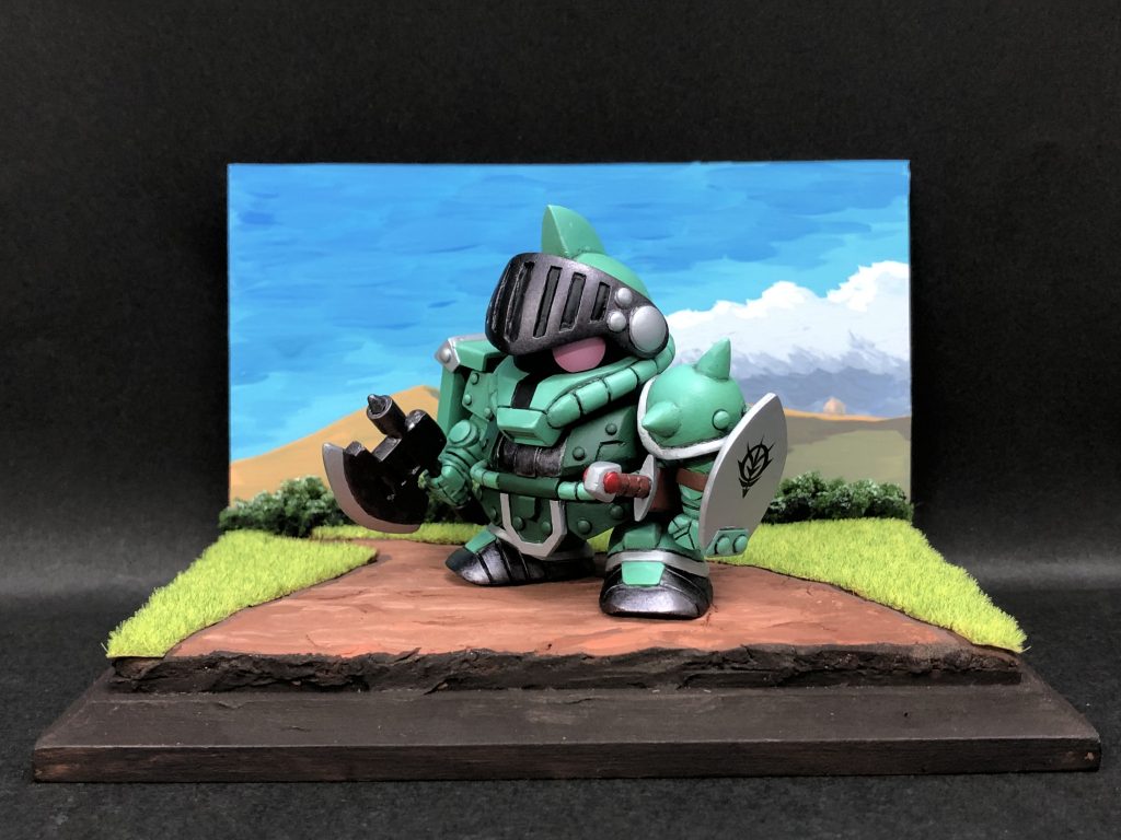 戦士ザクがあらわれた!簡単なジオラマ風台座を作りました。台座と芝と木のスポンジはホームセンター、紙粘土でベースを作り塗装は全てアクリルガッシュです。スーファミの大いなる遺産というゲームが世代なんです。戦士ザクは弱すぎて印象薄いですが。。。