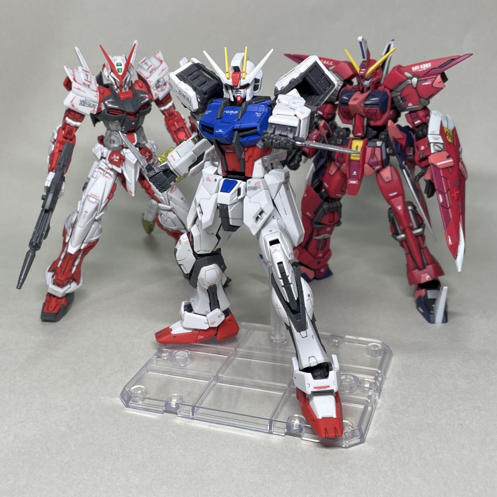 RGストライクガンダム、RGガンダムアストレイレッドフレームと並べてみました。　これらと並べたくて、時間をかけて塗り分けしてデカールを貼ったといっても過言ではありません。恐ろしいことにRG2体は、丁寧にペーパーがけをして最小限のみの部分塗装をし、シールを貼ってトップコートしただけのものです。　イージスガンダムには手持ちのデカールを貼ったので、RGのシールと統一感がなく、浮いている気がします。エッジも食玩準拠でだるいですが、後ろに置いておくのなら許容レベルにはなったと思います。