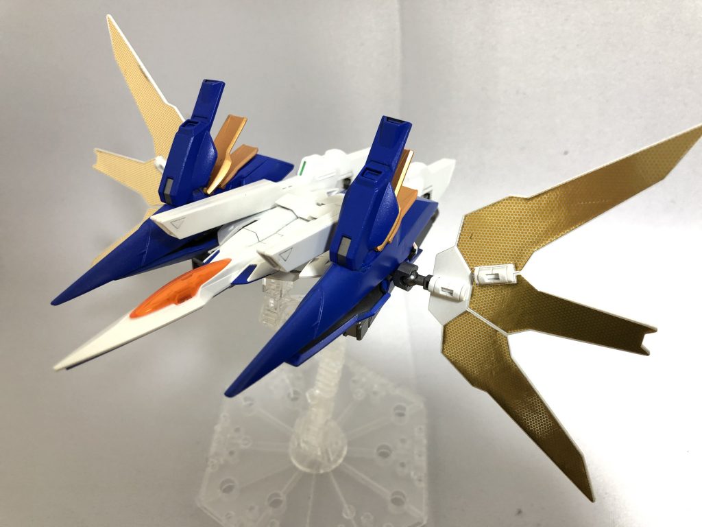 サテライトシステムガンダムDXから移植された機能。一見すると西暦世界には存在しない装備だが、AEUイナクトなどに搭載されていた「軌道エレベーターからエネルギーを供給し稼働時間を延長する技術」を参考にしたものと位置付けられている。このため月だけでなく、軌道エレベーターや人工衛星からの射線が通るバトルフィールドで使用することができる。擬似太陽炉と直結されており、受信したマイクロウェーブは電力へ変換されツインドライヴ状態の太陽炉へ直接供給される。瞬時に莫大な量の粒子を生成し、合体先の太陽炉搭載機への粒子供給や、自身の稼働時間の延長が可能。GNツインサテライトキャノンダブルエックスから移植された大型ビームキャノン。GN粒子を用いる仕様に変更されている。本体との合体時に肩部スコープおよびFCSと連動して使用するのが基本だが、精度は落ちるものの本機単独での発射も一応は可能。起動するとGNフィールドを最大出力で発動しながらリフレクターを展開し、マイクロウェーブを受信する。この際、内蔵バッテリーがチャージされることで、トランザムシステムを含めた全ての装備がリロードされ再使用可能となる。発射をキャンセルし、リロードのみを行うこともできる。GNフィールドを突破されると無防備となってしまうため、接敵中の使用は推奨されない。このため平常時は「戦闘中の本体から切り離した本機を後方へ移動させ、安全な場所でサテライトシステムを使用する」という運用がなされる。GNフィールド両脇の推進ユニット上部に搭載した1対のクラビカルアンテナを開き、GNフィールドを展開する。一般的な球状のフィールドは粒子の消費が激しいため、高速戦闘中は機体をローリングさせながら瞬間的にフィールドを展開する。並のビーム攻撃程度なら無効化することができるが、連続使用はできない。