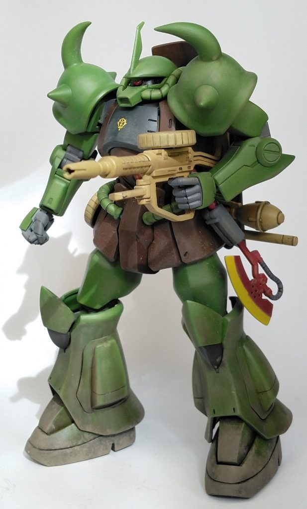 密林での視認性を低めるためのカラー変更です。ヒートホークも戦闘用というより、密林を切り開くための装備です。左手首は通常のマニピュレータです。右手で持つとヒートロッドが使えなくなるので左手で構えます。指バルカンでは連邦MSの装甲を撃ち抜けないでしょうから。