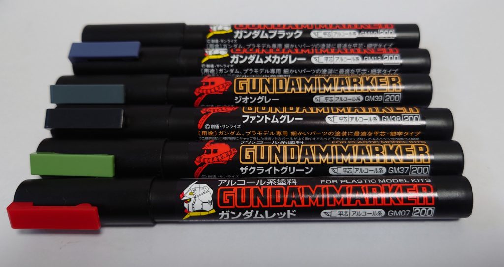 今回使った色。手前からガンダムレッド(スラスター内部)、ザクライトグリーン(胴体)、ファントムグレー(足、膝)、ジオングレー(四肢、ランドセル、武器)、ガンダムメカグレー(関節)、ガンダムブラック(モノアイ、スカート裏、スリット等)