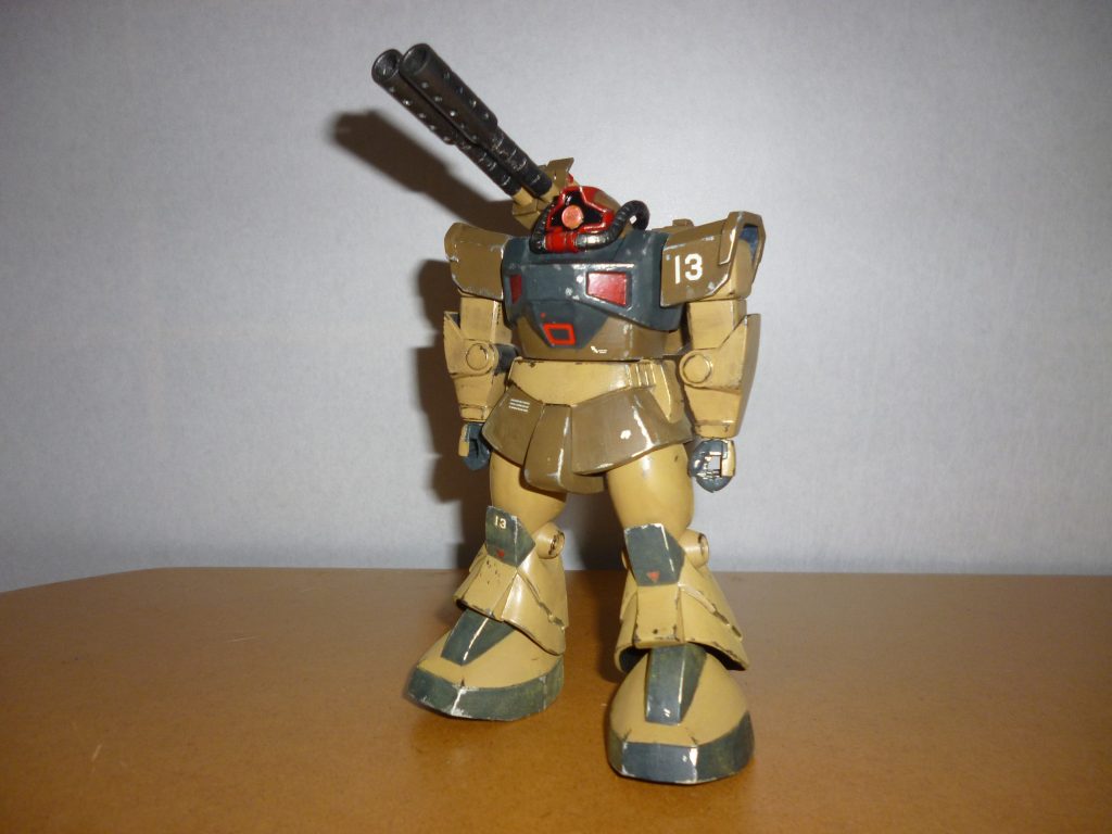 　正面素立ちです。　使用したキットは1/144のMSV「プロトタイプ・ドム」です。　基本塗装はサンディブラウン、ダークアース、ミッドナイトブルーの３色に、黒鉄色と赤を部分的に使用しています。ダークアースは、以前投稿したルッグンの塗装にも使用した、ミドルストーンとオリーブドラブにレッドブラウンを少量混ぜた自作のカラーです（塗料ビンにストックしておきました）。　これらを塗装した後、つや消しを全身に塗ってからマーキング、銀色と黒鉄色でウェザリング、仕上げに全身に、黄土色と黒色のパステルを削った粉を平筆ではたいてあります。