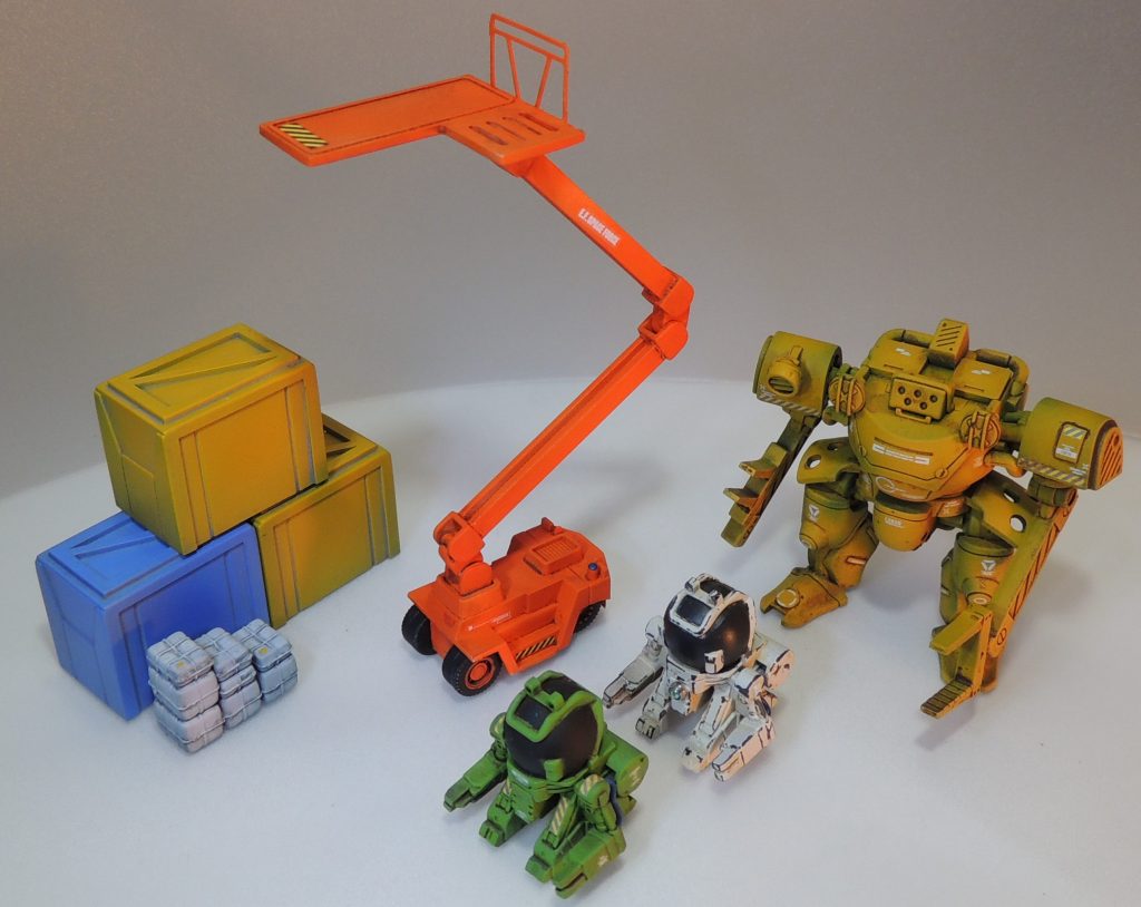 高所作業車は、Ｎゲージのフォークリフトを土台とし、プラ材とジャンクパーツで支柱等を自作しました。プチモビはＨＧカスタマイズキャンペーンの部品から。ドラケンはジムスナⅡ付属品を流用。荷物はＮゲージ等を使用しています。