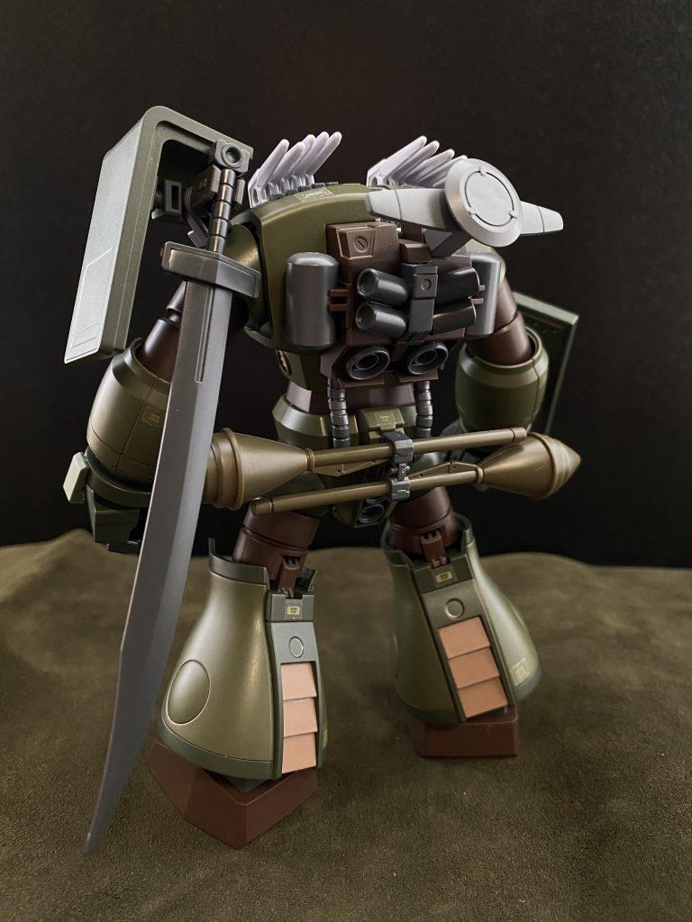 　格納庫ヘ向かうオレの目に、格納庫に向け何やら難しい顔をして腕組みをしているヨルク伍長を見つける。最近、エンデが拾って、オレ達の隊に組み入れたヤツだ。生意気だが、狙撃の腕は大したものだ。オレの方から格納庫の中は見えない、おそらく格納庫の中のオレの新しい愛機を見て、羨ましがっているのだろう。「ヨルク伍長！良いだろう。オレの新しい愛機は！」　そう声を掛けるオレを、どこかキョトンとした顔でオレを見る伍長は、オレが近づくにつれその端正な顔を、みるみる内に歪め、顔を背ける。なんだ、失礼なヤツめ。そんな伍長の隣に立ち、格納庫の方を、我が愛機を見上げる。「な…、なんだ…、コ、コイツわ…」　オレが見上げる、その先には、グフでも、ドムでもなく、まるで…、まるで、小さな子供が描いた、一つ目の怪物の様な