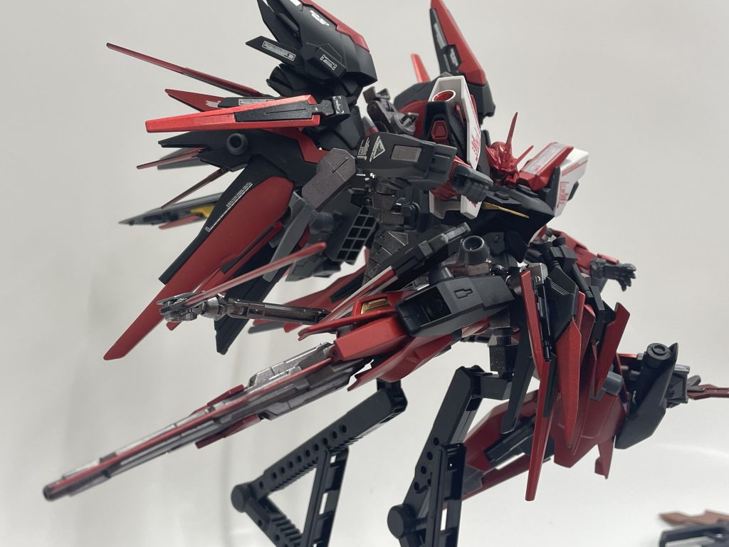 　その姿を異形のシルエットたらしめる要因の一つ、脚部に搭載されたGNソードⅡブラスターだ。射撃、簡易な近接戦闘を可能とする為…又、多方向から襲い来る敵に対応するためには足でも、腕でも頭でも、その全てに「武器」としての意味を求めた。アンクルアーマーに位置する部分には、ミサイル迎撃用のバルカン砲が搭載されている。