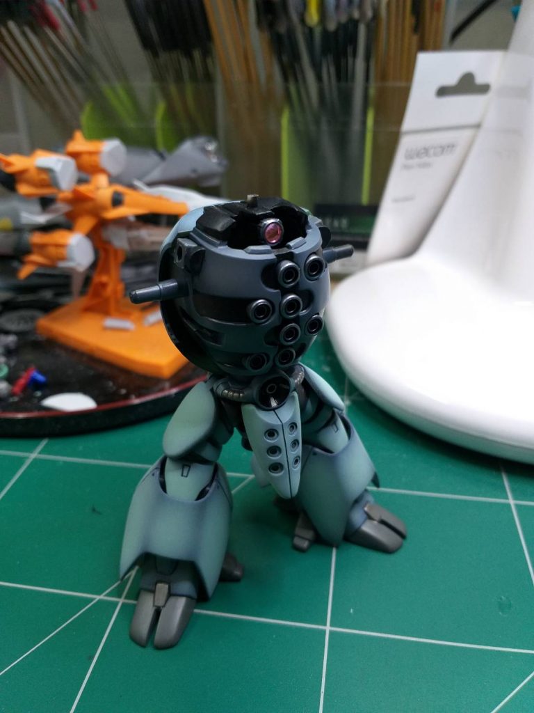 モノアイの可動加工です。胸部と一体成型となっていたモノアイ部をざっくりとくりぬき、残った頭頂部に2mm穴をあけ、そこを軸に回転するようにしました。モノアイはビルダーズパーツのセンサー(ピンク)です。