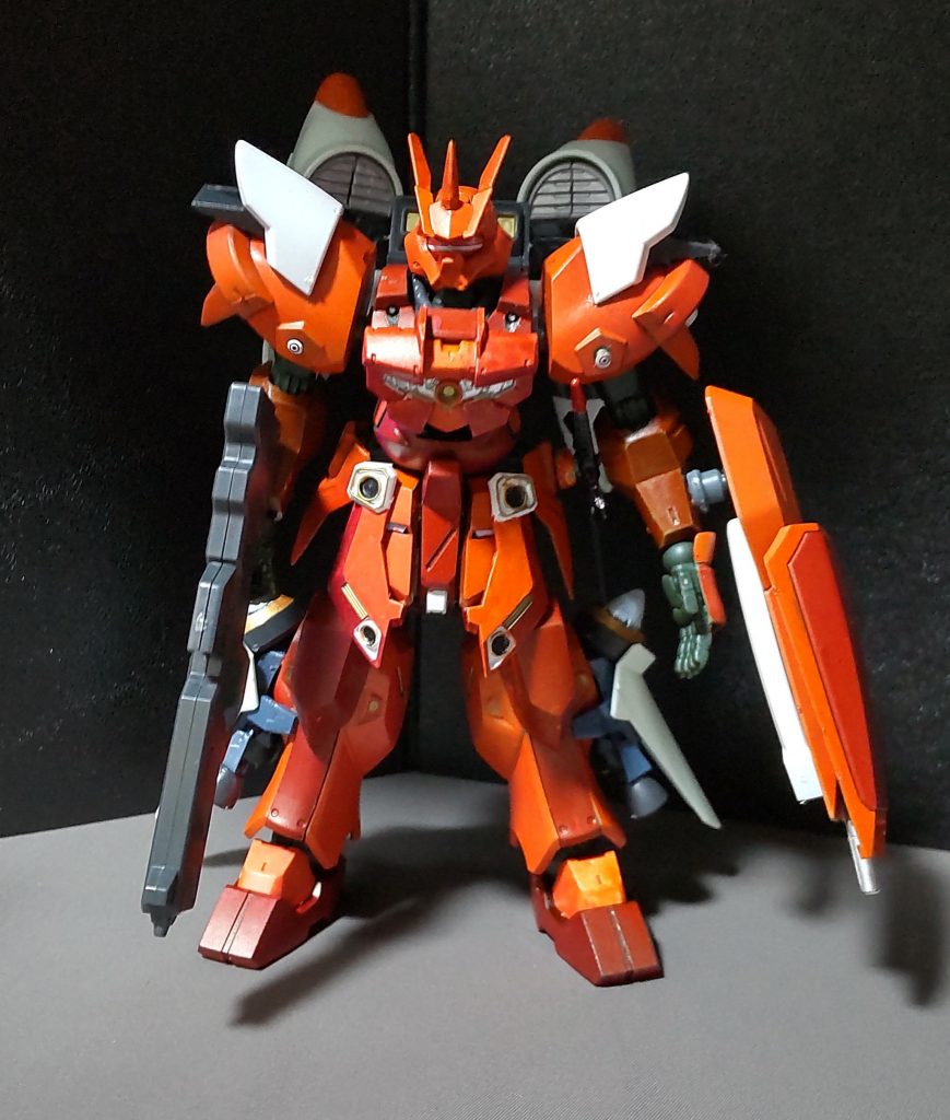 ジャハナムのボディにジンハイマニューバの各装甲のパーツを移植させた事で、見た目も重装甲かつ高機動型と、かなり変わりました。各部の改良点について○頭部30MMシリーズのフェイスパーツを切り取ったのを接着し、一本角として、パーツ取り用に購入していたヴァイエイトの頭部パーツを付けました。○胸部追加装甲として30MMシリーズの装甲を接着。中心の発射口からは低出力のビームが撃てるが、ドムの拡散ビーム砲と同じ位なので、目眩まし位に使用される程度である。○肩部ジンハイマニューバに付いていた装甲を移植。○腰部スカートアーマーにジンハイマニューバの装甲の一部を移植。○脚部ジンハイマニューバの脚部スラスターを移植。○シールドガンダムmk2のシールドの下半分を重ねて接着し、シールドの先端に銃口を接着しました。また、可動域の干渉の軽減の為に、従来の位置より少し下げて装備するようにしました。