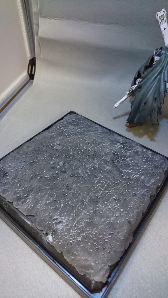 今回作った台座ですが、ホビーベース プレミアムパーツコレクションの底の部分に木粉粘土を盛り、その上にタイル補修用のセメントを塗って作りました。さらにそこからつや消しブラックを吹いた後にライトグレーでドライブラシをして色味を整えてます。