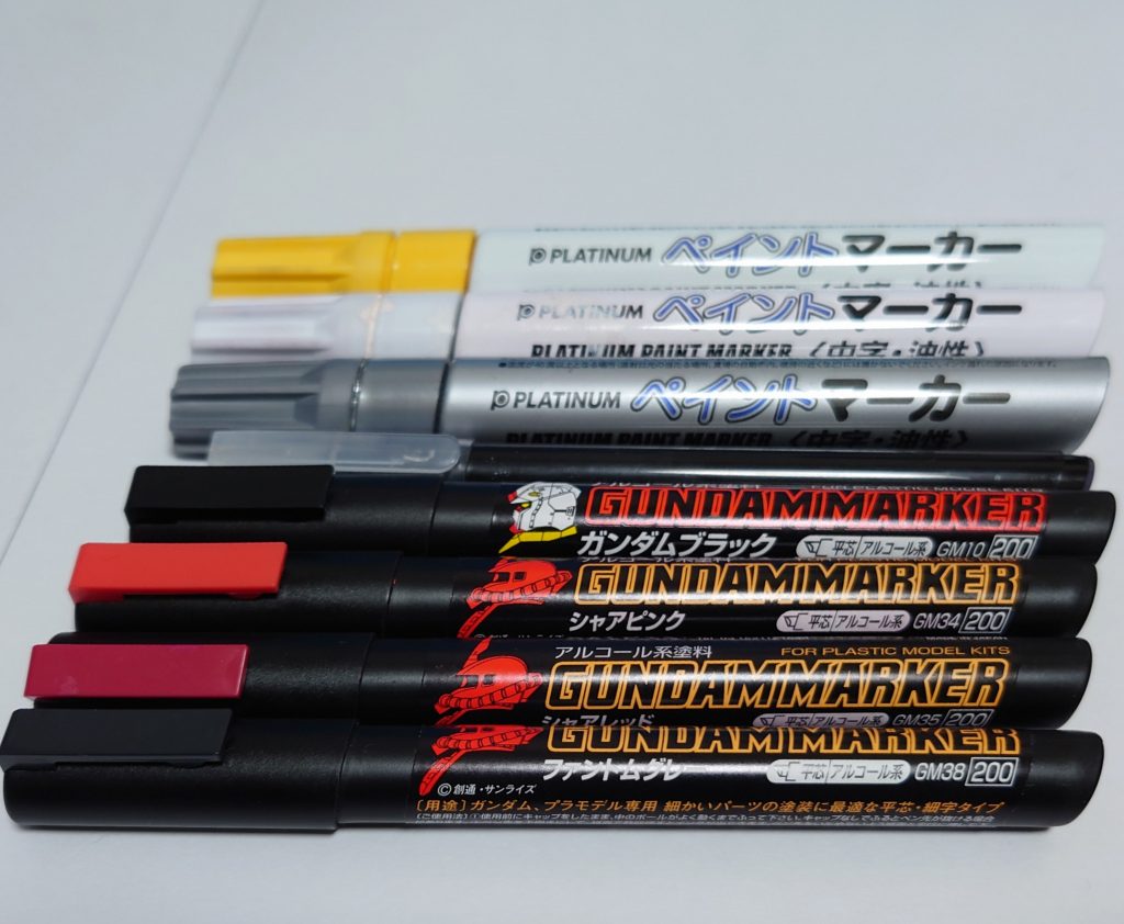 今回使ったカラー。ガンマカのファントムグレー、シャアレッド、シャアピンク、ガンダムブラックで塗装、マーキングにペイントマーカーの白と黄とガンマカ黒、スミイレにカラー筆ペン(グレー)、チッピングはペイントマーカー銀。