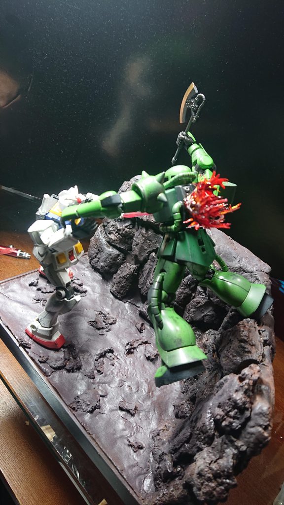 ガンダムのビームサーベルと右腕、ザクの右足の3点でバランスをとってます。量産型ザクが手に入らなくてシャアザクを塗り直し(^_^)