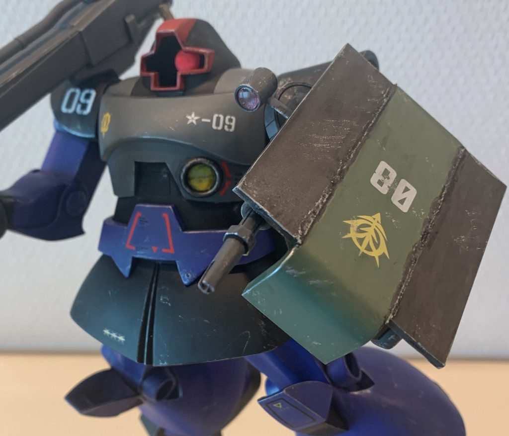 左手は増加装甲を施したザクシールドを持っています。ザクシールドのままだとドムの巨体をカバーできないので、現場で装甲を貼り合わせて防御面積を拡げた、という妄想設定です。旧キットの量産型ザクのシールドにプラ板を接着し、境目は伸ばしランナーをあてがい接着剤でフニャフニャしたところを棒でグチグチして溶接痕っぽい感じにしてみました。スケール考えるとどんだけデカい溶接痕なんだって感じですが(笑)、まあ急造DIY兵器っぽい雰囲気は出せたかなと思います。最初は左手には何も持たせるつもりは無かったのですが、キットのままだとあまりにも造りが甘く、かといって改造できる腕もなく、でも高いサードパーティ製を買うのは嫌だったので苦肉の策でシールドを持たせました。