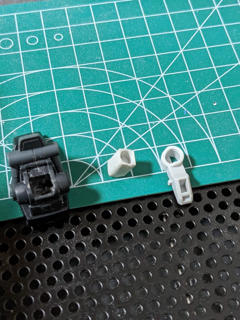 制作中2。HGの足そのまま使用するとポリキャップ抜けそうだったので、CSフレーム足パーツを切断、ボールジョイントがハマる部分のみに。写真右はSDフレーム足パーツ。HGパーツもポリキャップがハマる部分を加工し奥までパーツが入るように。写真左が加工後。CSフレームパーツの残した部分がHGパーツの四角い穴に入らないため、写真中のようにパーツを削って成形。塗装後に接着。