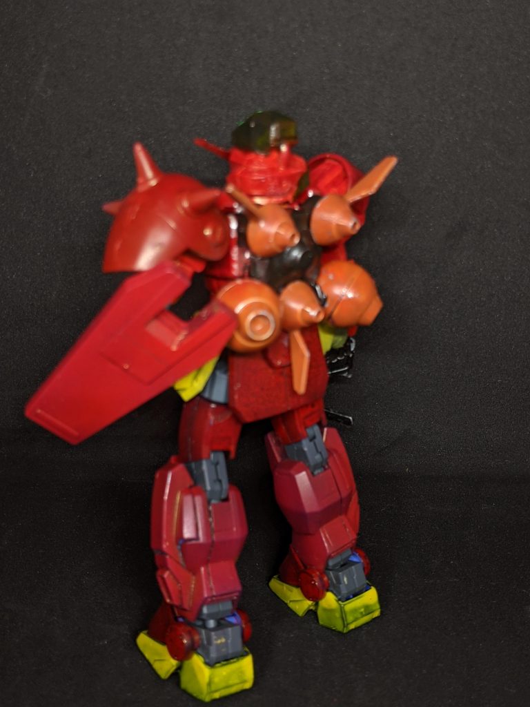 背面はドライセンのバックパックで同様にトライブレードを使用。カラーリングはシャア・アズナブルを彷彿させる赤を基調とする事でレジスタンスの求心力や結束力を高める狙いがある。