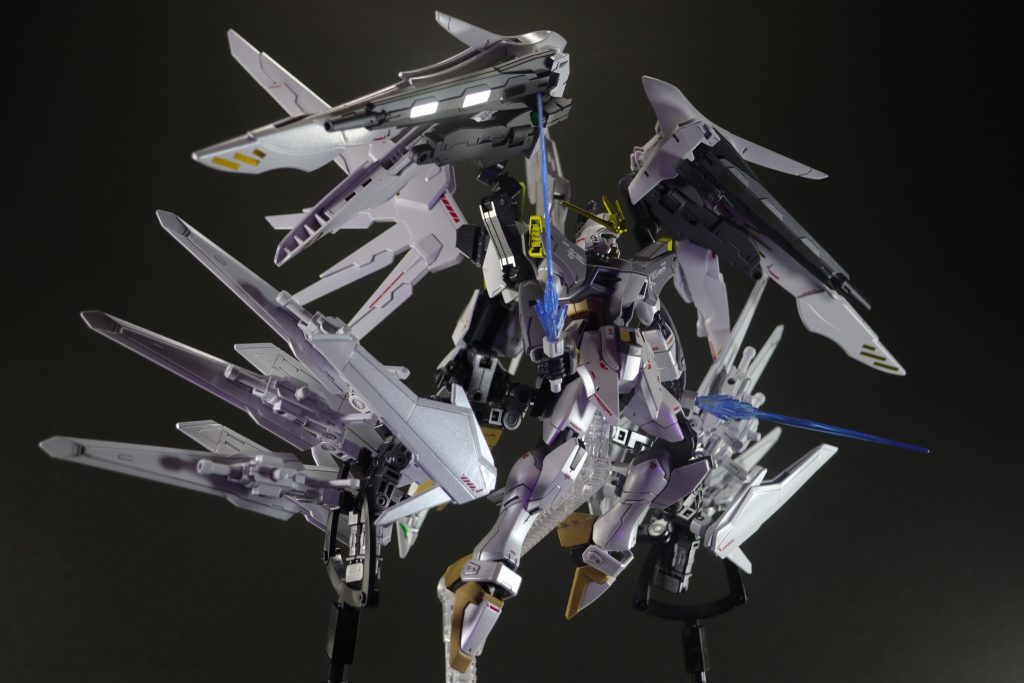 背面プラットフォームのヴォワチュール・リュミエールユニット上部には、大型ビームサーベルも搭載されている。ビームサーベル底部はビームキャノンとなっており、威力は低いが連射性に優れるためツインバスターライフルでは威力が大きすぎる対象に使用される。また、ビームサーベル同士を縦列に連結することで、より大出力のビームソードを形成することもできる。以上で解説を終わりにします。国家試験勉強であったり、試験に行けなくなったりと、なかなかガンプラに触れる機会がありませんでしたが、ようやく完成させることができました。長々とした解説が邪魔だったかもしれませんが、見ていただいてありがとうございました。来年こそは国家試験を受けるために試験勉強を頑張らねばならないので、また投稿できない期間が続きますが、次回の作品も見ていただけたら幸いです。