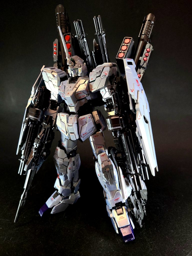 なお、防御面においてはシールドが1枚から3枚に増えた以外に装甲（＝アーマー）は追加されていないため、正確には「フルアーマー」と名乗ることが適切なのかといった旨が、原作小説の文章中でも触れられていた。しかし、タクヤがこの強化プランに「フルアーマー・ユニコーンガンダム」と命名して提出したことから、この名称で呼称されることとなった。両前腕部と背中にシールドを合計3枚装備することで防御性能も向上しているが、本仕様の主眼はあくまで火力の増強にあるため、機体名称の「フルアーマー」は「armament＝武装」の意だったと言える[59][60]。一見、寄せ集めで何ら計算されていないような強化形態に見えるが、タクヤは上手く帳尻を合わせて機体のアンバランス化を防いでいる上、これらの装備はデストロイモードへの変身も一切妨げないように考慮して取り付けられている。背中の装備類も含めた全火器をリモートで使用可能となっており、パイロットの思考をダイレクトに機体へ投影させるユニコーンのインテンション・オートマチック・システムと連動することで、パイロットによる目標の探知と呼応し、ある程度は自動で照準を行ってくれる上[61]、複数の対象に対して複数の武装で同時攻撃する戦法も可能であり、本機の仕様が継戦能力の向上のみならず「瞬間的な最大火力の行使」という本来の攻撃特性をも強化させている[62]。単純に大量の武装を装備させるだけならば通常のMSでも可能だが、通常のMSが搭載するメインコンピューターの情報処理能力では、これだけの武装を個別かつ最適にコントロールして運用することは不可能であり、量子コンピューターと同等とされるフル・サイコフレーム機の演算能力によって実現した運用方法と言え[30][注 3]、演算処理能力とインテンション・オートマチック・システムによる自動照準が合わさることで、その大火力の真価を発揮せしめた。