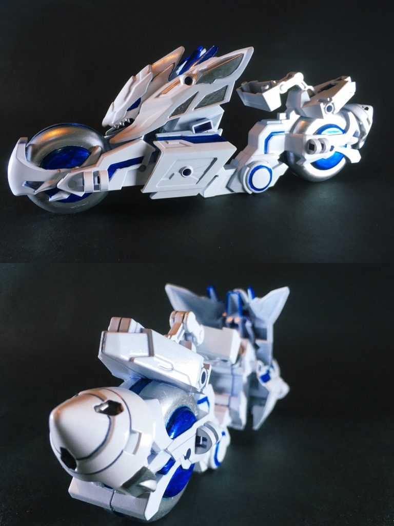 トリニティバイク(趙雲の碧竜駆)は演者MSに合わせた白・青・銀のカラーに変更しました(後部にGNドライブも1基追加)。文鴦ダブルオースカイメビウスは背部バックパックがGNドライブ基部とウイングユニット基部の二重接続となっていて嵩張るためバイクの搭乗スペースに座れませんが、そちらを逆手にとって(?)立ち乗り専用で疾駆する設定とさせて頂きました。足裏のジョイント部に接続するためバイク側の接続パーツを表裏反対に組み込んだり、立ち乗りに伴うバランス制御のためバイク底部にミニ四駆用のウエイトパーツを仕込んで安定性を向上させるなど工夫しています。