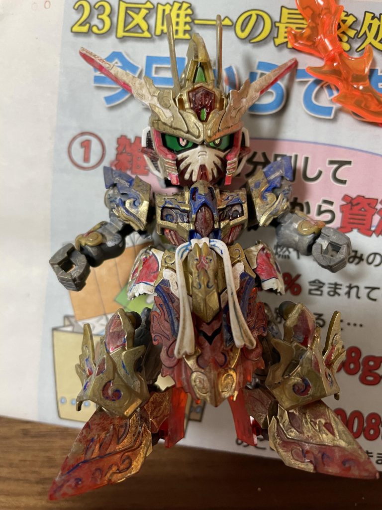 背中の炎はビルドバーニングガンダムより拝借。全体にウェザリングカラーのホワイト、ブランを全体に塗ってぼかしをかけます（ランナーで塗った４アーティストマーカーの黄色が溶けたのは誤算…）スミ入れは水性絵の具の藍色を使い、チッピングで銀とレッドブラウン、ウェザリングマスターで足回りはマッド、部分的にはアカサビを塗っています。反省点としては足のウェザリングをかけすぎて他の箇所より彩度が落ちてボケた感じになって統一感が失われてしまったことです。ウェザリングの下限は難しいです。龍の頭部や炎は黄色と白のドライブラシをかけています。理想としては美しいグラデーションにしたかったのですが、ドライブラシのザラッとした感じが頭で考えていたものとは違っていました。ただ、ドライブラシで際立ったエッジはらいだ〜Joeさん、林さんに良いコメントをもらえましたので、また挑戦してみたいと思います。目には偏光素材の紙を貼り付けてあるので、角度によって目の色が変わります。ぜひ掲載した写真をもう一度見て、何色になっているか確認してみてください。以上、悟空インパルスガンダム「炎王光の型」でした！また次回作もよろしくお願いいたします！