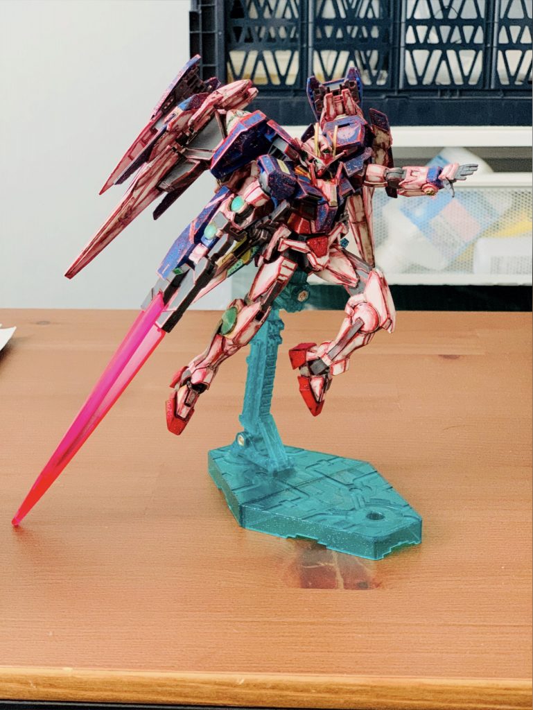 ガンダムマーカーのメタレッドで各所エッジ部を塗装。以前のなんちゃってイラスト風のときと同様に大袈裟に塗り付けて手書き感が出るよう意識しました。色パーツ部分には100均ラメのりを塗り付け、クリアパーツは同じく100均で購入したUVレジンに蓄光パウダーを混ぜ込んだものを塗布して発光するようにしました。肩回りがやや寂しかったので蓄光シールをカットし取り付け、その上にデカールを組み合わせて貼りOOの文字を浮かび上がらせました。