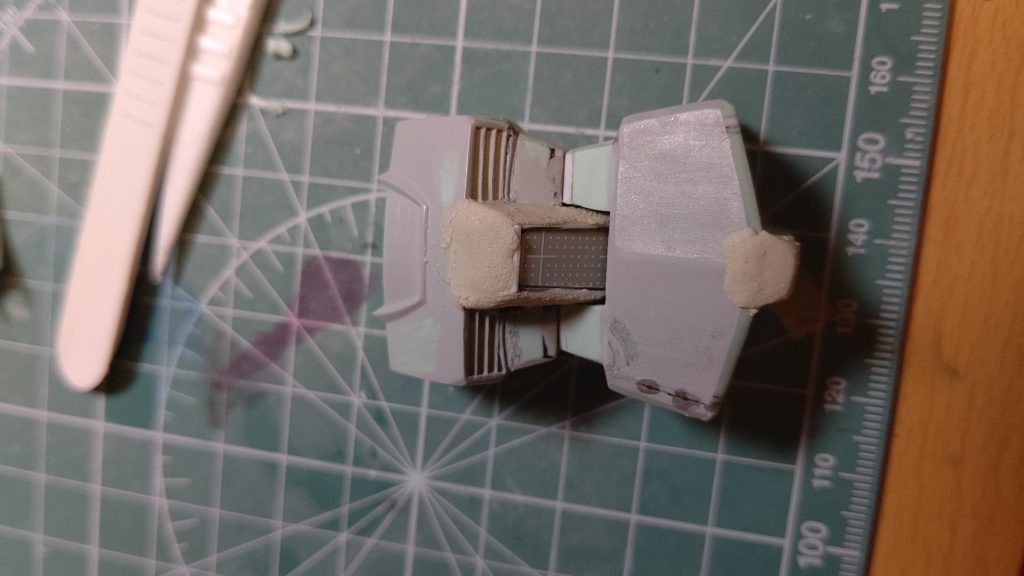 胴体の工作。腹部はくびれの位置で切断、2㎜延長コックピットハッチはプラ板で新造パンツの裾は切り込みにプラ板でくさびを入れて広げて、設定画には無い四隅のC面を無くしました。