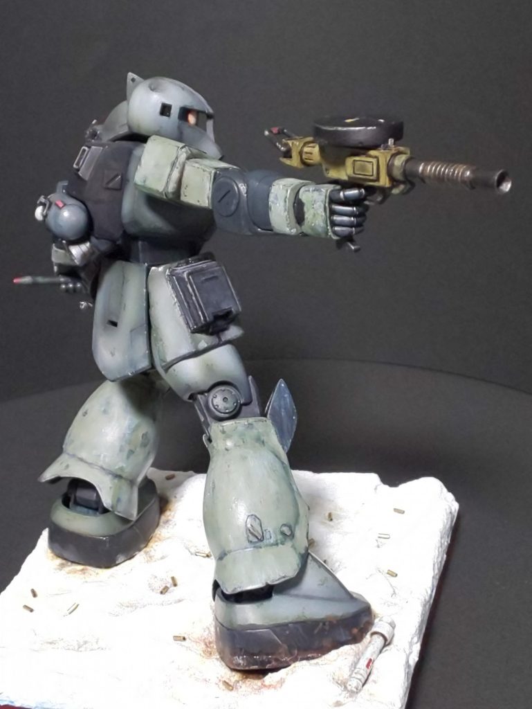 「なるほどわからない話ではありません。ですが総理、別カラーにした場合とそうでない場合の比較算出をしましたか?してないでしょう。みなさんのお手元にある資料からもそれは明白です。“リメイクするなら新作と言える程のものにしなければ意味がない” これは前のプラモ再生法の時の総理のご発言です。覚えてらっしゃいますね?この言葉を有言実行するなら別カラーにすべきだったんではないですか?!」「え~、その言葉はよく覚えています。確か砂ドムの時です。忘れたわけではありません。その証拠という訳ではありませんが、ザク1にも加筆しております。確かに御指摘の通り本体はそのままですがザク1スナイパーのジャンクから流用した腕脚には剥げた冬季迷彩をかけております。また、ジャンプ用ブースターや背面のタンク等は新しく作り足しており、ご周知の通り台座も新たに作っております。」