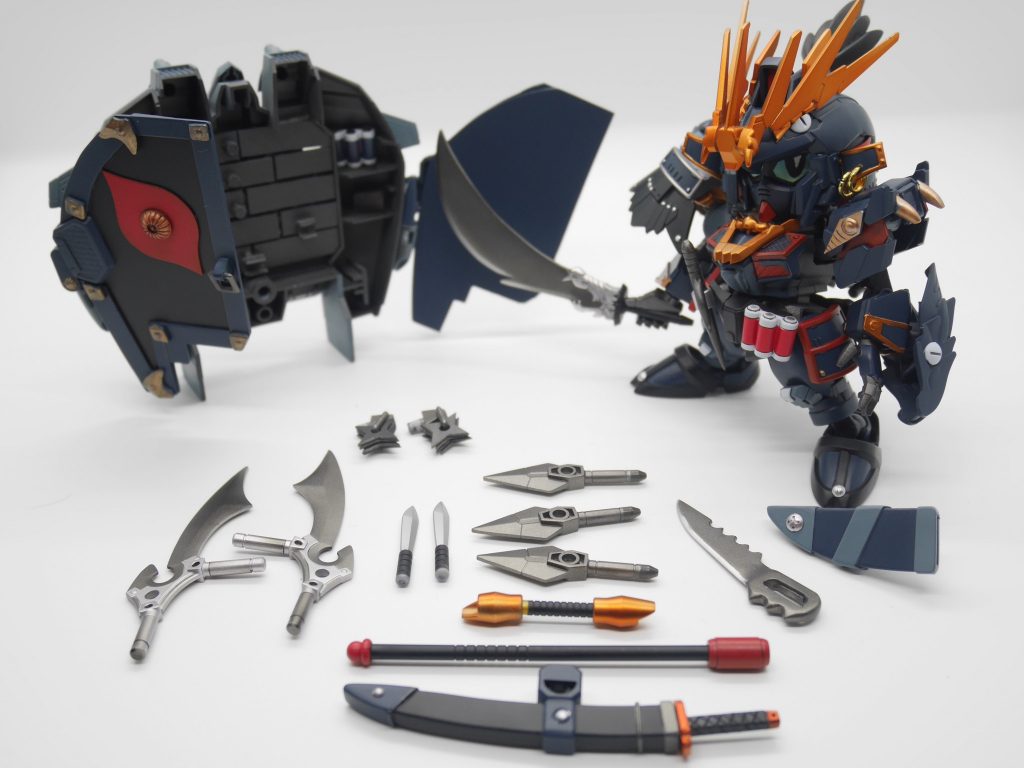 傭兵稼業ゆえ各国の数多の武器を所持している、任務の内容に合わせ最適な武器を選び持ち出している。［大蛇丸モチーフ］ガンダムUCよりデルタプラス→バンシィデルタプラスの状態はSD戦国伝の百鬼丸のシルエットに、これは大蛇丸が殺駆雲斎の里の先輩百鬼丸に憧れてその格好を真似しているという設定です。バンシィの状態は阿修羅頑駄無をモチーフ、あと隠密頑駄無が換装で農丸頑駄無になるところをオマージュ。ベースジャバーには黒魔神の黒幻眼の模様を入れてます。初代大蛇丸がこの秘技を編み出すきっかけが、黒魔神の力の一片に触れたことという設定から入れました。