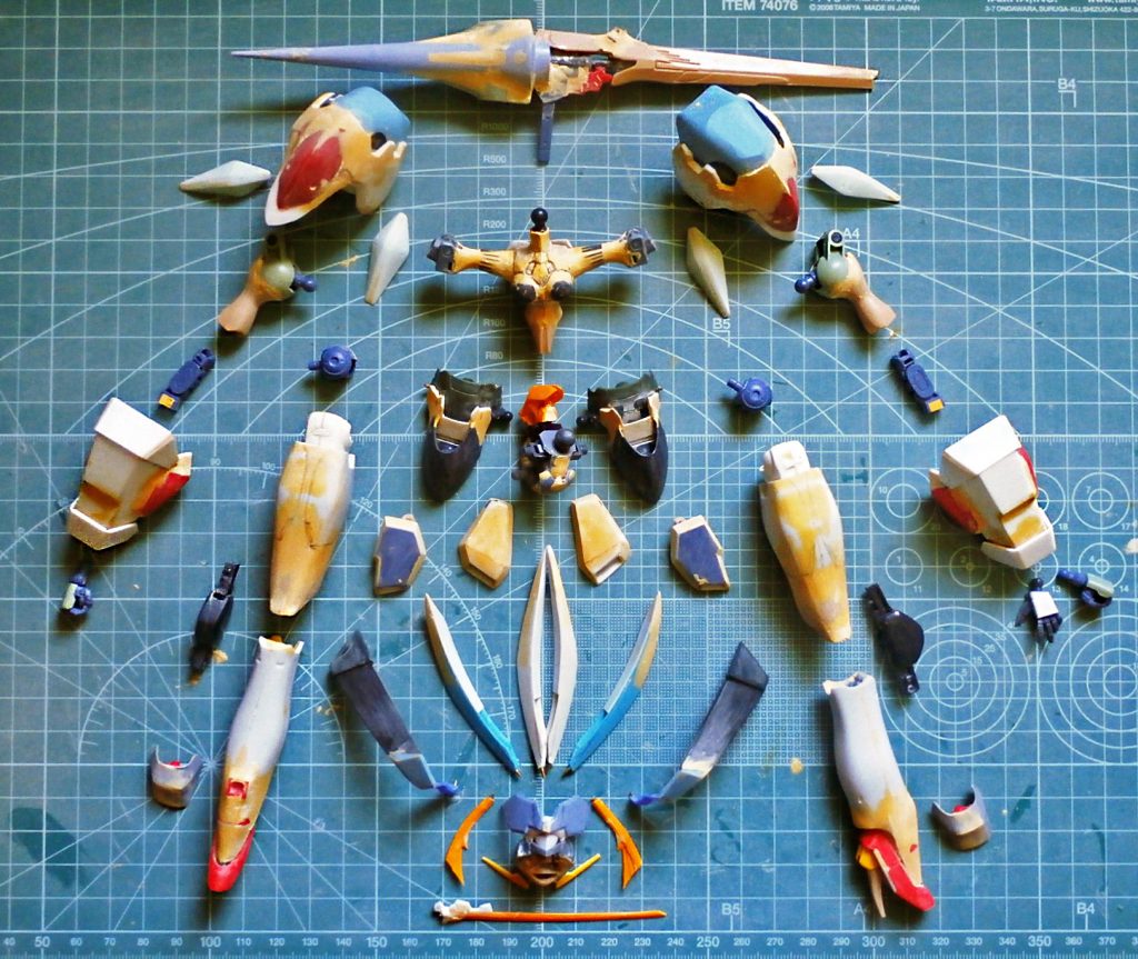 パーツ展開図。武器のクイーンパイクは、オリジナルデザインからかけ離れたものになりましたが、ノリとカッコ良さ優先で。マンロディの足パーツを切削調整して「ジンクス」のランスに接着し整形、ブレンパワードの火器を前後逆にとりつけストックとしています。子供の頃、中途半端に改造したまま箱にしまって、そのまま完成させられなかったプラモがいくつもありました。このストレリチアはなぜ完成させられたのか。つや消しコートが乾燥した後、製作マットの上に立たせながら考えたのは、“これはあくまで習作で、いろいろなトライ＆エラーを気負いなくできたから” 完成に繋がったんじゃないかということでした。長いブランクからの復帰1作目なので粗いところもありますが、自分の模型人生において“フルスクラッチしたことがある”と思えることは、最高に嬉しいことです。