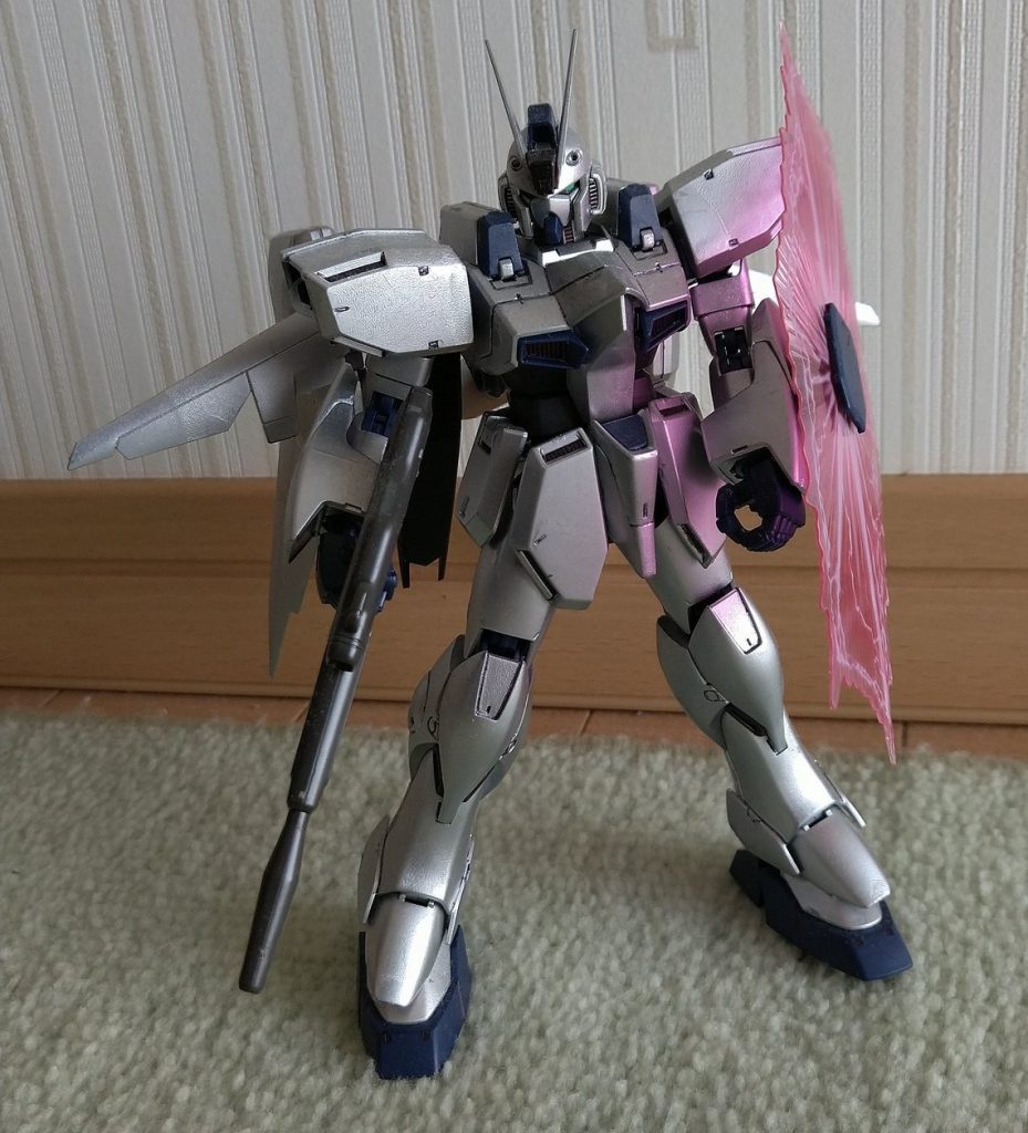 ガンイージを買ったものの、後でプレミアムバンダイからREガンブラスターの発売が決定。予算の都合でガンブラスターを断念し、代わりにこのガンプラを作るとこにしました。工程としては、REガンイージをベースに、エース専用機ということで、ガンダムタイプを意識してV字アンテナを取り付けました。色はアサヒペンのメッキ調スプレーのシルバーでほぼ全塗装しています。ところが、このメッキ調スプレーは手で触ると塗装が付くという問題があります。と言う訳で、塗装の上からトップコートを吹き付けています。