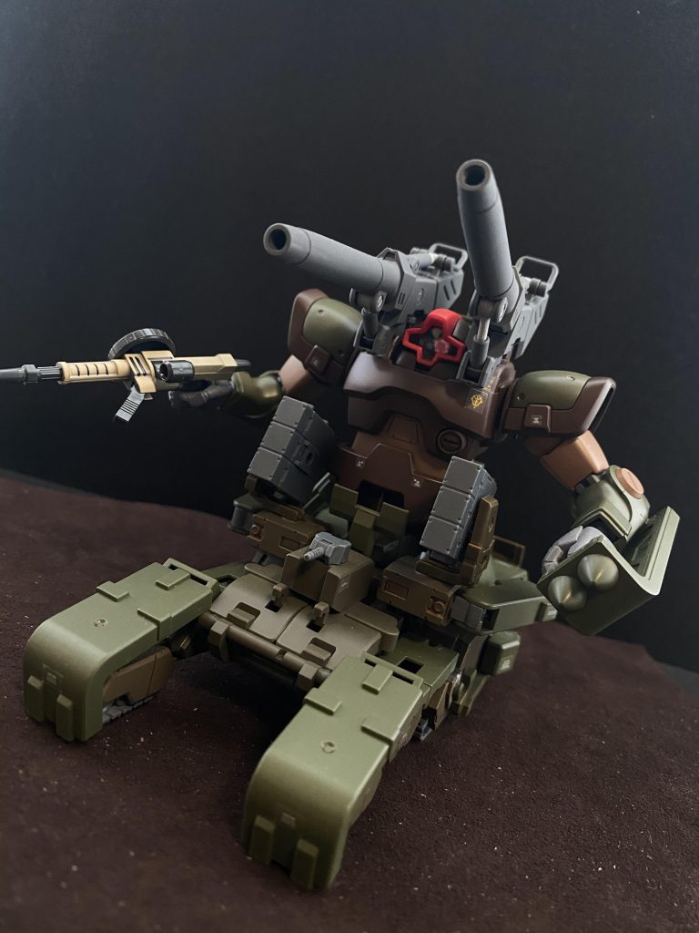 ドムパンツァーMS部 肩部に装備された大口径砲が目立つ。無理矢理装着された為、命中精度は低い。その為、HE弾、HEAT弾など榴弾系の弾装が装填される。他には、三連ミサイルを二基、右腕に、ドムを受領する前から使用してきたザクマシンガンを装備している。