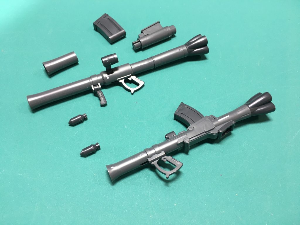 009。「THE ORIGIN」用にデザインされたザク用のバズーカ2種。下の方にあるD1型は組み替え無しでこの形状で固定。 上にあるバズーカはF型でもおなじみのB1型に加えて、マガジンがつくC1、B2型にもできます。旧キットの武器セットのようにバズーカの弾頭が付属します。あっちに比べるとクオリティは段違いです。