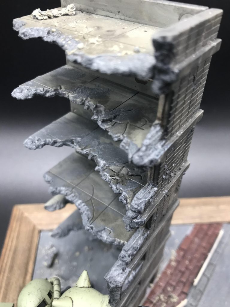 トミーテックの破壊されたビルをウェザリングマスターのマルチブラックでウォッシング。全体的にウェザリングマスターのススを使って汚しつつ、コンクリート部分は情景テクスチャのダークグレーを塗って境界を誤魔化しています。