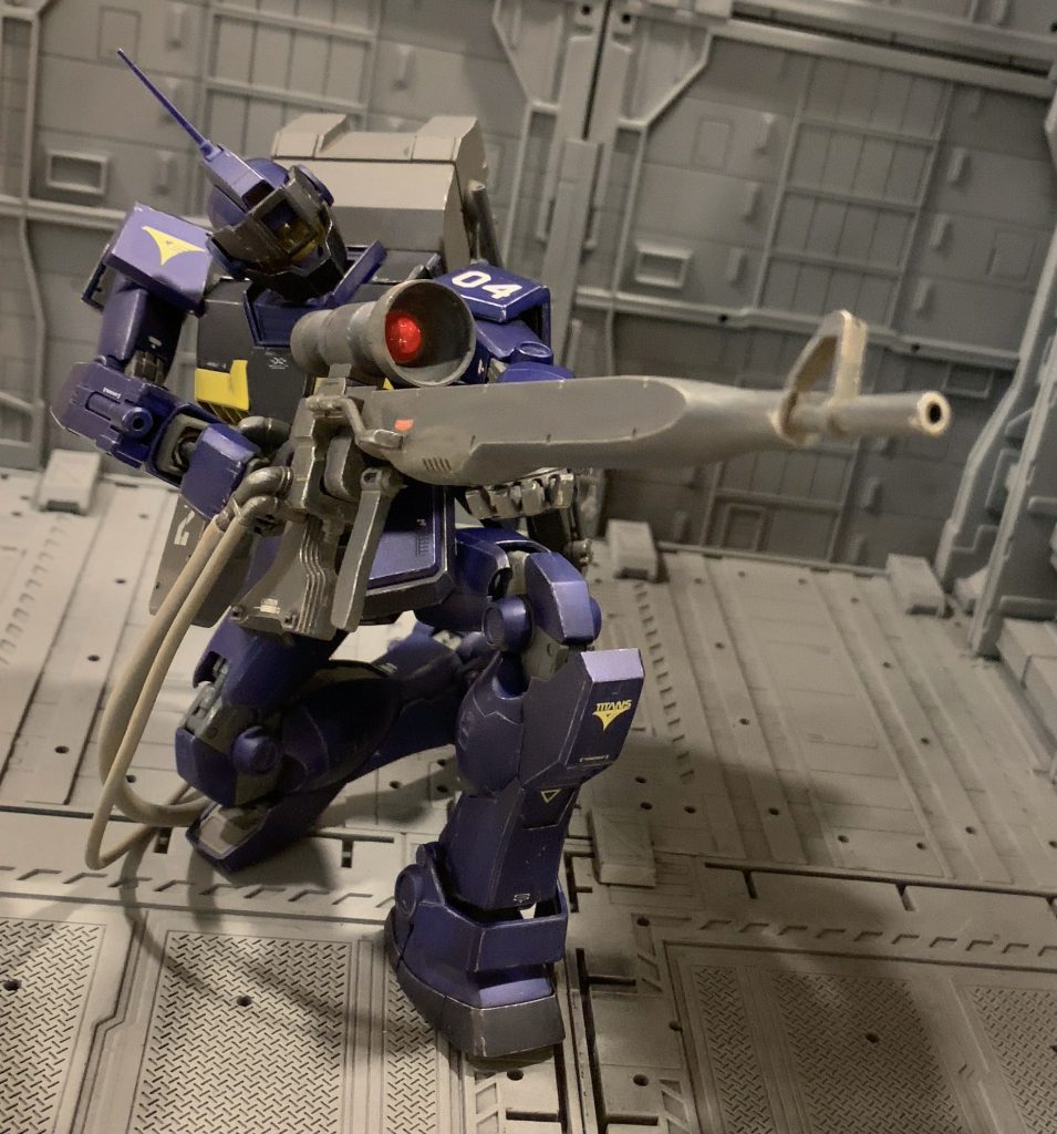 パイロットはマシンガンの弾薬を自ら一発一発検品し、ブラシで洗浄してから装填するようなストイックで職人気質な人物をイメージしました。映画「山猫は眠らない」のトム・べレンジャーみたいな、気難しそうなおっさんです。思いっきりステレオタイプな意見ですが、スナイパーと言ったらやっぱり冷静沈着で寡黙な「ザ・仕事人」というイメージですよね(笑)一年戦争時からずっとスナイパーカスタムに乗っており、自分の手足のように扱えるベテランです。ティターンズに志願した理由は出世欲やアースノイドのエリート意識からではなく、純粋なジオンに対する憎しみ、という方がしっくりきそうです。手垢まみれのベタ中のベタ設定ですが、シドニー出身でコロニー落としで故郷も家族も全て失った的な。