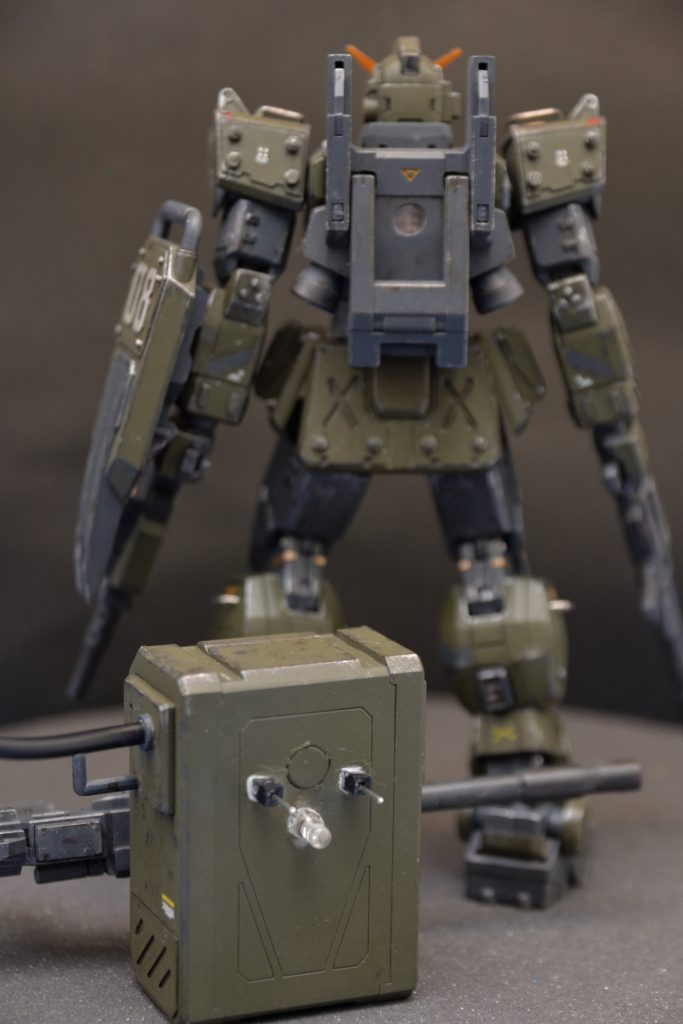 バックパックから突き出た2本のピンは、背中を貫通して胸の中へ。真ん中のLEDが背中の穴にはまって、内部から背中のスラスターを照らします。バックパックの側面から出たケーブルは、キャノン砲に繋がって先端のLEDを光らせます。