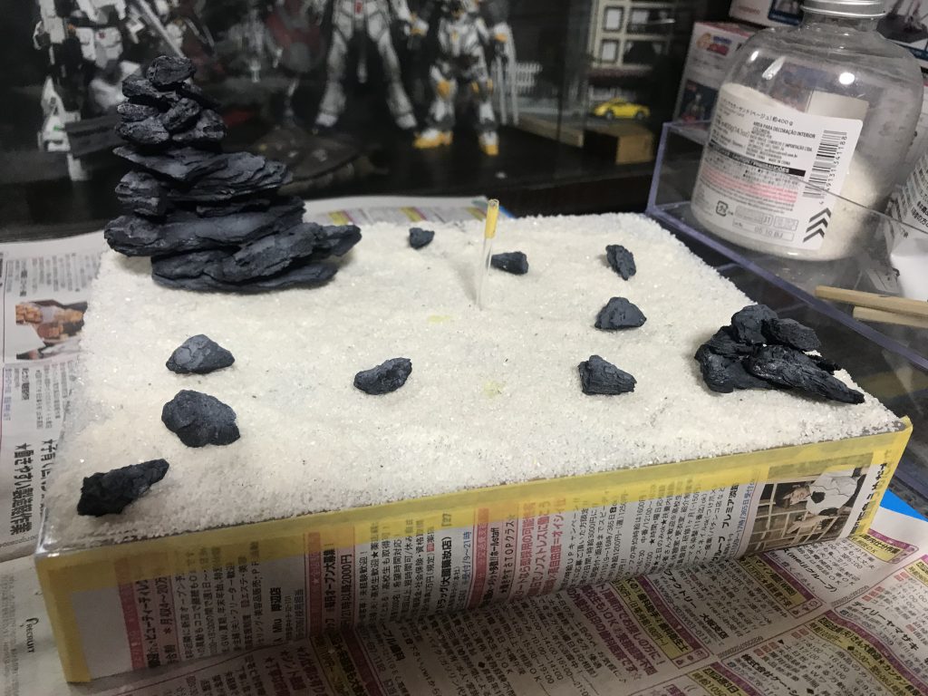 白砂を木工用ボンドと水を混ぜたモノを霧吹きに入れて吹き付けて接着バークチップは岩風に塗装ベースはクリアーケース