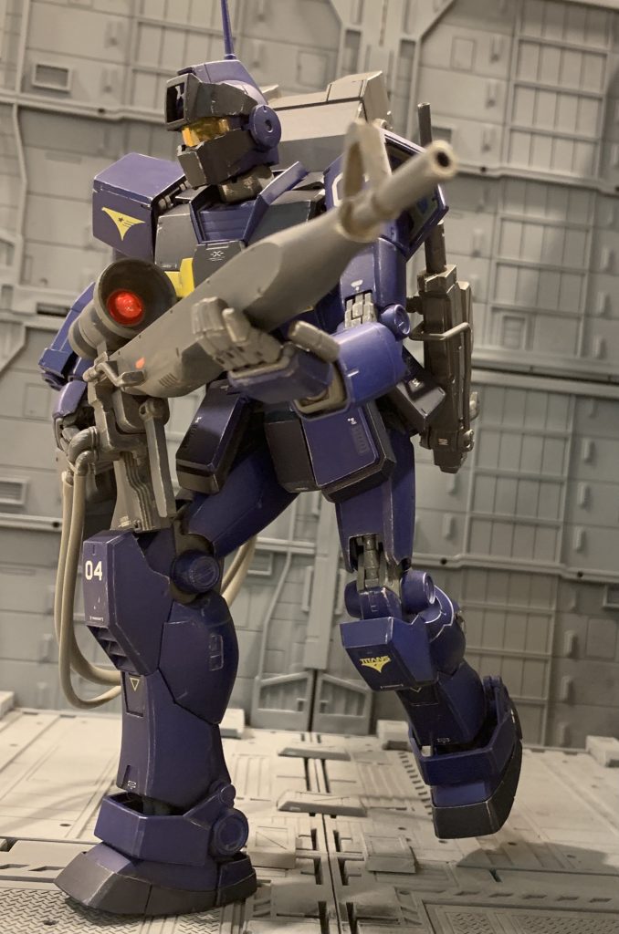 重力下で大重量の狙撃システムを背負うため、宙間制御用の脚部バーニアと推進剤タンクは外され、空いたスペースを使って脚部フィールドモーターの耐久性＆出力アップが施されています。これにより重力下での踏破性がアップし、険しい地形でも素早い陣地転換を可能とし、常に最適な狙撃位置を確保できるようにしています。バーニアを増強しジャンプした方が高速移動は可能ですが、スナイパーという性質上敵に察知される事が任務遂行の致命的な支障になるケースが多く、隠密性を確保したうえでの機動力向上を図っています。