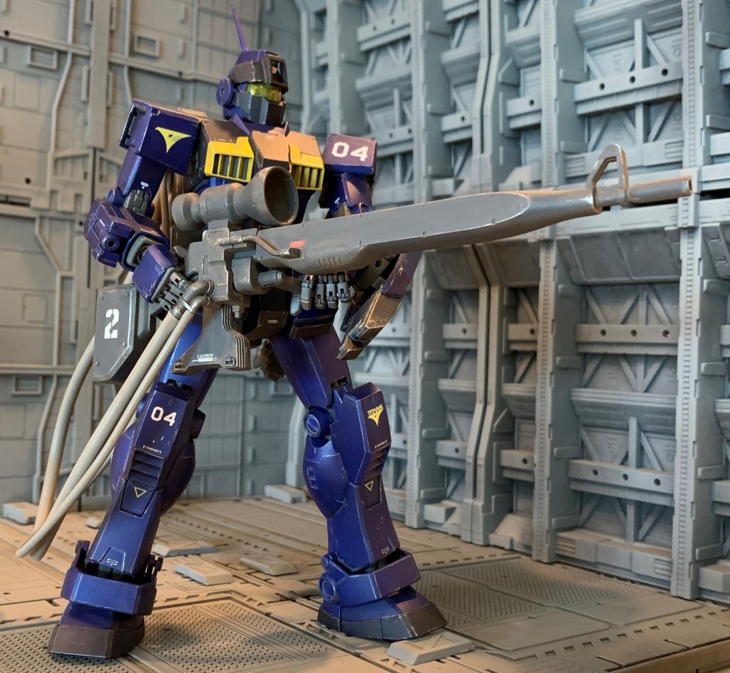 交戦対象となるジオン残党は軍隊ではなく、いわば小規模なテロリストの集合体です。なので組織的な大規模行動は滅多に出来ず、少数でゲリラ戦を展開し、連邦の施設を占拠したり民間人を人質に取り資金、物資の略奪や政治的要求、破壊活動をするような、所謂「不正規戦闘」が多発していました。星の屑作戦後しばらくの間、ジオン残党は特に分散しており、更にティターンズによる強硬な圧力によって、非戦闘地域を多く含む世界各地で小規模な不正規戦闘が増加していました。自軍支配地域内での戦闘においては、流れ弾や爆発等による副次的被害を最小限に抑えなければなりません。このような戦闘の性質上、重装備のMS部隊で前線を構築して面で制圧するのではなく、敵の警戒域の外からスナイパーによる点の狙撃の方が有効である場合も多く、その運用にローコストで即配備できる戦力としてジム・スナイパーカスタムの狙撃特化装備案が提案、採用されました。といった感じの経緯です。