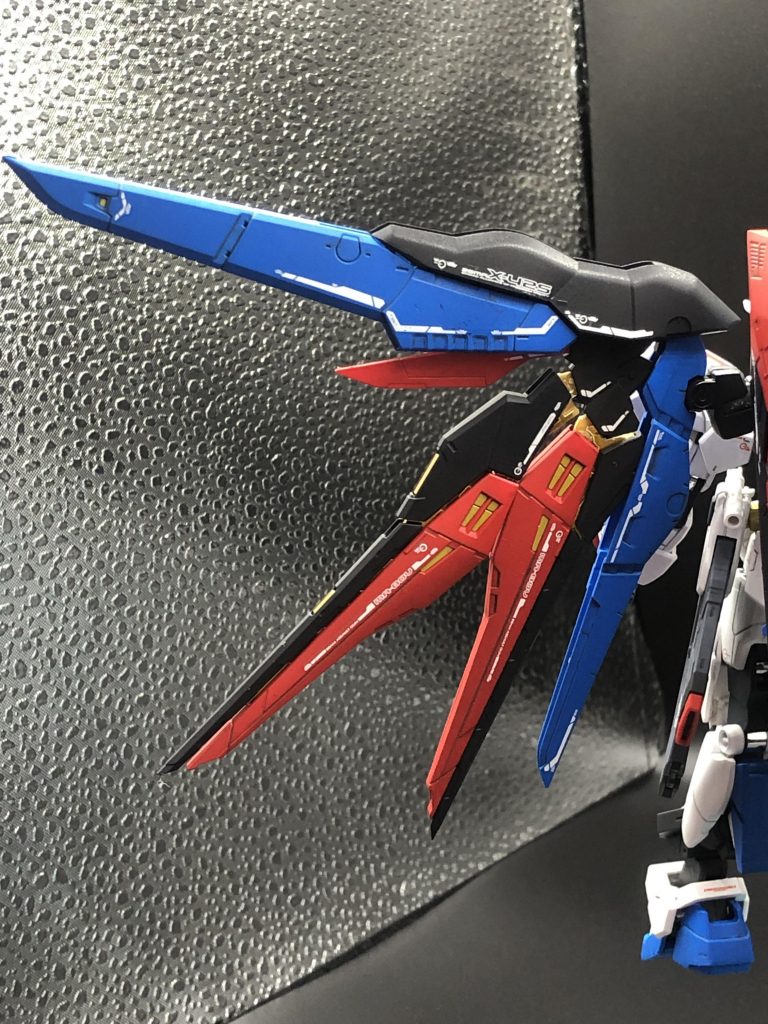 ストフリの翼とデスティニーの翼をミキシングしています。デスティニーベースの翼にすることで、ミラージュコロイドを散布しながら高速移動する、いわゆる残像ダッシュが可能な設定。敵のロックオンを切りながら高速移動し、射撃並走をばらまく、ガンダムVSシリーズで言うところの「逃げ撃ち」を得意とする射撃機体として設計しています。