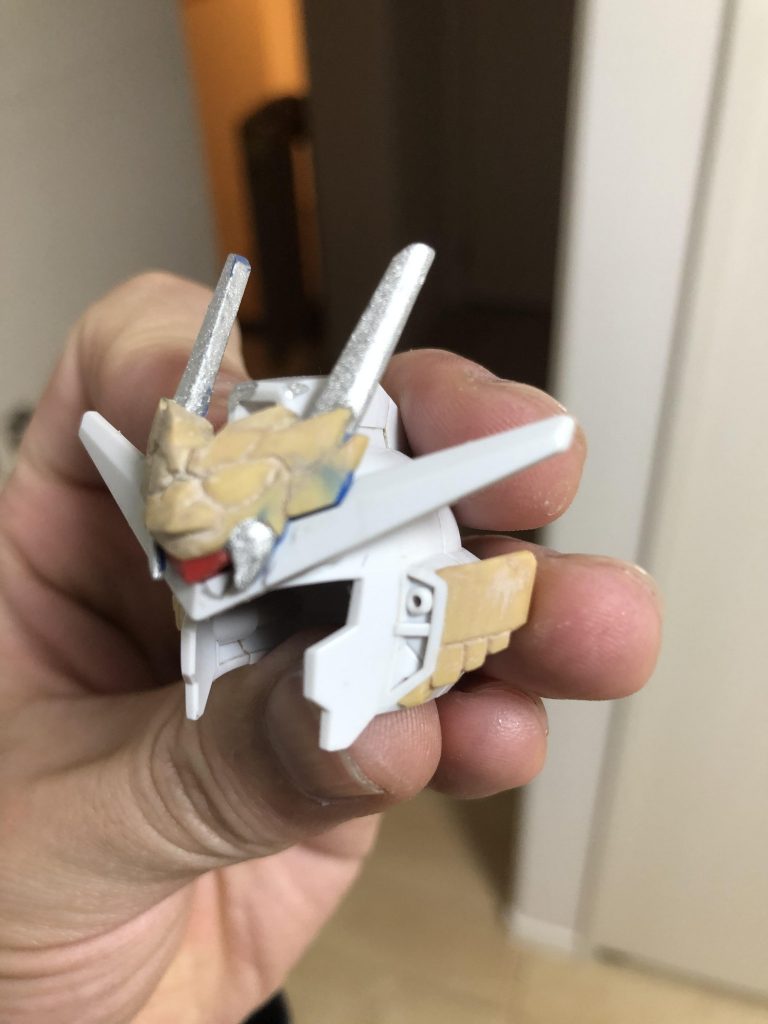 ここからは、製作工程にござる。言わずもがな、ベースはSDCSアースリィガンダム。アースアーマーの追加アンテナにパテを盛り盛り、チーク部ダクト横にもパテを盛り盛りして、ピックとカッターで削って彫って、『武神の前立て』や『吹き返し』を少しずつ整形していきました。