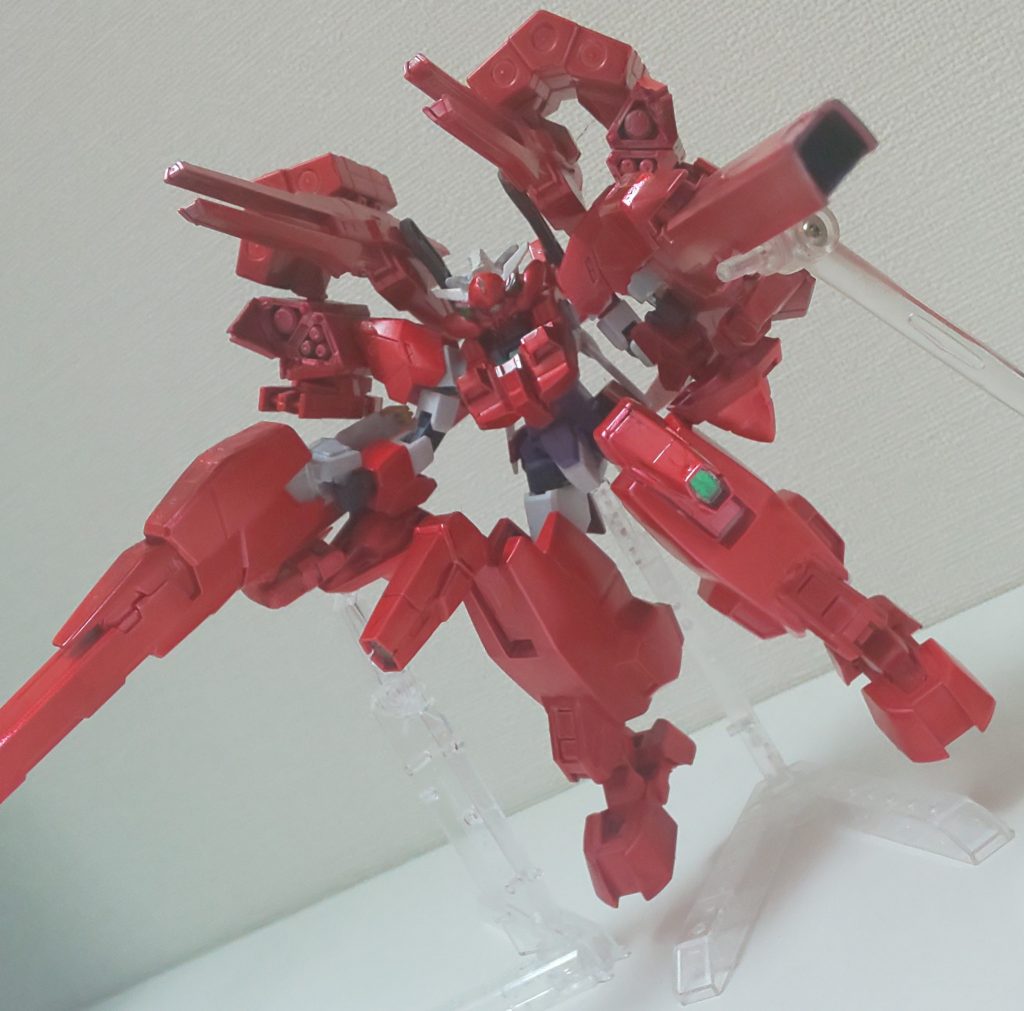 バックパックと肩パーツが一体となっているHWSには大型、中型、小型ミサイルポッド、GNマルチミサイルランチャー、大型ランサーミサイルが、足アーマーにはGNキャノンとミサイルベイがそれぞれ2基ずつ装備されている。メイン武装は腕アーマーとビームバスタークローが合体した大型のキャノン砲「GNレインヒートブラスター」。腕アーマーに装着されている擬似GNドライヴから直接粒子を装填し圧縮をすることで高火力の砲撃を可能とし、さらにチャージする事で戦艦の主砲を超える高火力の砲撃を行うことが出来る。ただし、チャージ/クールタイムが掛かること、擬似GNドライヴという事もあり使い過ぎるとエネルギー切れで機体制御も難しくなるのであまり連発は出来ない。