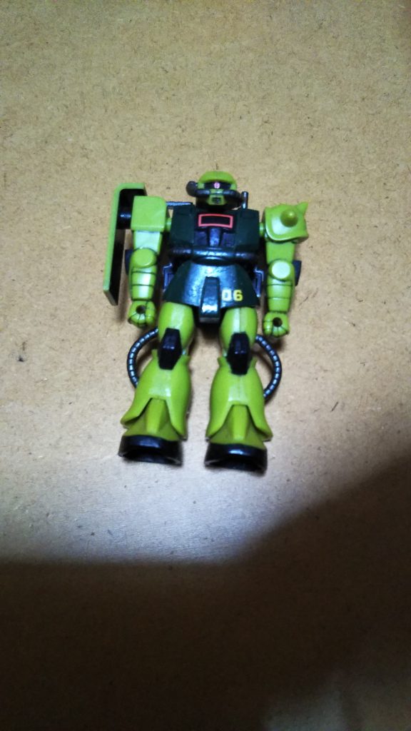 　光源の関係なのか、立ち姿ではモノアイが上手く映らなかったので寝かせてみました。　やはりザクはモノアイをアピールしておかないと（笑）。　そういえばこのキット、大きさに反して実は1/144のＭＳＶキットよりアップグレードしている点もたくさんあります。　具体的には・すべてのパーツが接着剤不要のスナップフィットになっている・足首や太ももの付け根がボールジョイントになって可動範囲が良くなっている・シールドが円柱状の軸による差し込み式になっていて、腕を動かしてもある程度角度が調整可能・手首に穴が空いているので、やろうと思えば他のキットから武装を移植して持たせることができる特に最後の「武器を装備可能」という点は、個人的にはかなりポイントが高いですね。　そのうちザクマシンガンでも自作して持たせてみようかな・・・？