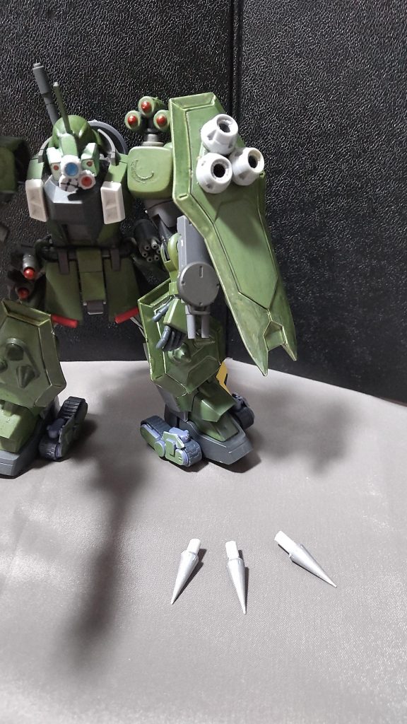 ・耐ビームシールド&スモークディスチャージャーそれぞれ左肩に装着されている。ザクウォーリアにも装備されている対ビームコーティングを施したシールドで、表面に3本のトゲがついている。このトゲを活用してシールドバッシュ(所謂タックル)をやったりもする。本機はそのトゲ部分を改良し、より鋭くし、さらにトゲを撃ち出すといったニードルショット機能を持たせている。スモークディスチャージャーはかく乱、散開、撤退時などに利用される。相当な煙の量に加え、相手のセンサーを一時的に無効にする機能がある。