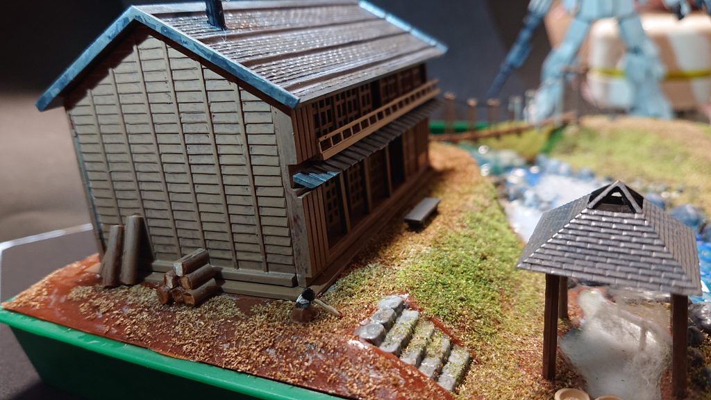 温泉宿を別の角度から。建物や小物類も塗装して、地面は茶と緑のパウダーを振りかけています。建物脇の丸太は説明書の指示通りランナー枠部分を切って設置しました。⬇️以下、制作工程です。