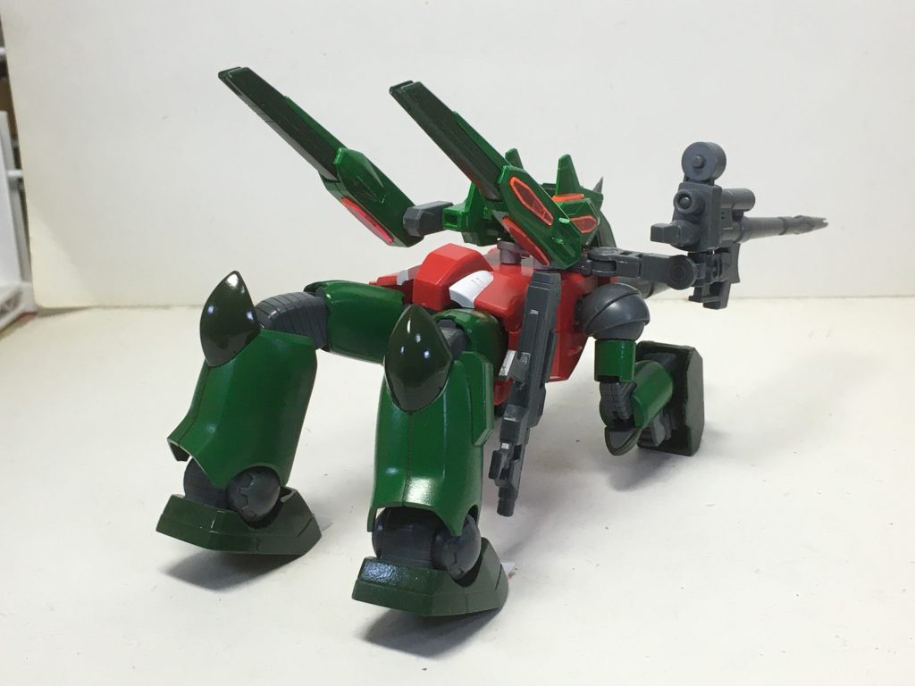 前腕のプロテクターが、マニピュレーターを隠すように全面に稼働し、キャノンも前方を向き、バックパックの中心部が回転して犬のような形態になります。下半身は180°回転して若干つま先立ちにしています。この形態のヒントとして、フラウロスを参考にし、ライフルの構えはガイアガンダムを意識しています。