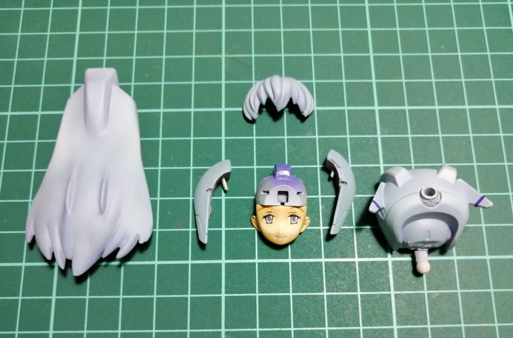 頭部の分解図です。各パーツの位置をいじっているので、真鍮線等を使い後ハメできるようにしてあります。前髪はボリュームアップ、後ろ髪は少し横に広がった感じで、髪の毛っぽい形状に変更してみました。顔は目やまつ毛などのモールドを埋め、ほうれい線っぽく見える部分を削り、アゴ等を幼く見えるようにやや丸目に削ってあります。