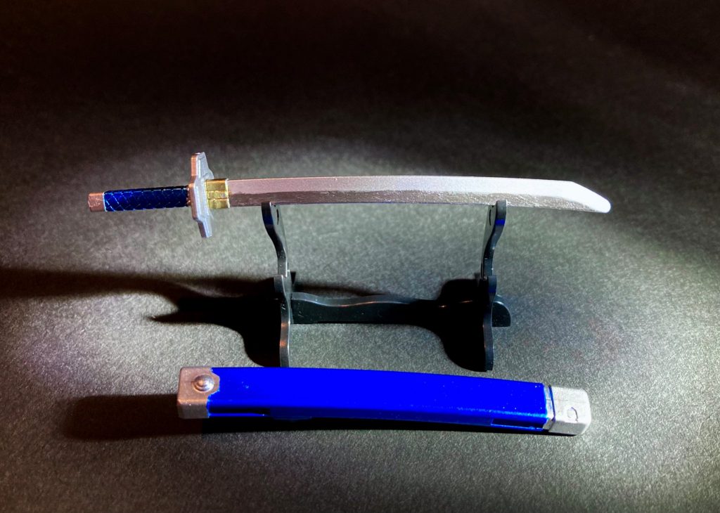 【倶利伽羅江】南北朝時代の伝説的刀匠・郷義弘の作。越前国朝倉家に伝来し、元亀年間の一乗谷合戦で光秀が保護。以後秘蔵の愛刀として重宝した。本能寺🔥戦役後、坂本落城🏯に際しても敵方に明け渡さず、死出の旅路を共にした逸話は『川角太閤記』に曰く「松永弾正の平蜘蛛に同じ」と評された。 〜〜〜〜〜〜〜〜〜〜〜〜本編では利休ガンダム・ダーク信長エピオン・才蔵デルタカイの登場と怒涛の展開の中で噛ませ犬的末路を辿ってしまったヒーローズ光秀ではありましたが、個人的にとても好きな戦国武将なので、今回このようにモチーフ製作させて頂けて大変楽しい体験となりました。以上、文章が長くなってしまい申し訳ありませんが、閲覧頂きありがとうございました。